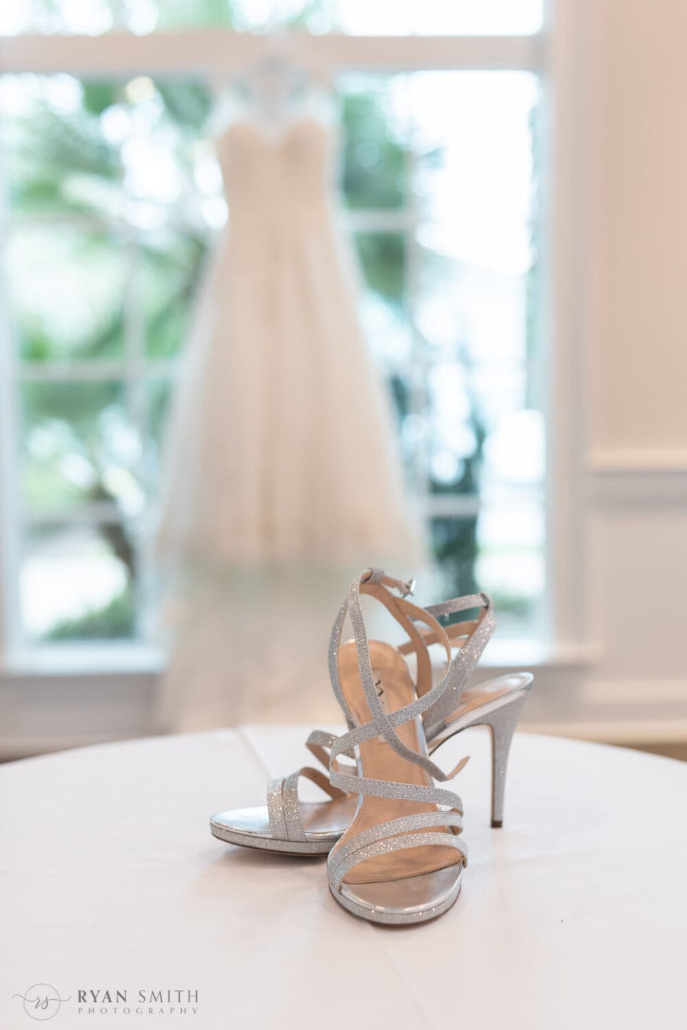 Bride's shoes in focus with dress hanging in the background - 21 Main Events at North Beach