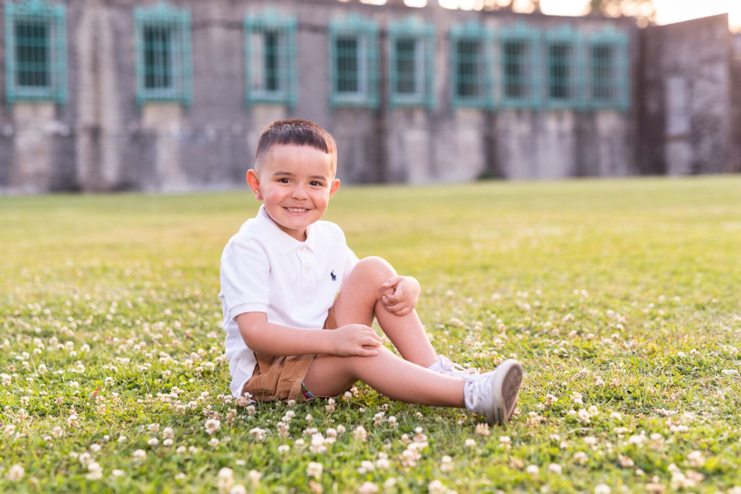 Little boy sitting in the grass in front of the castle - Huntington Beach State Park