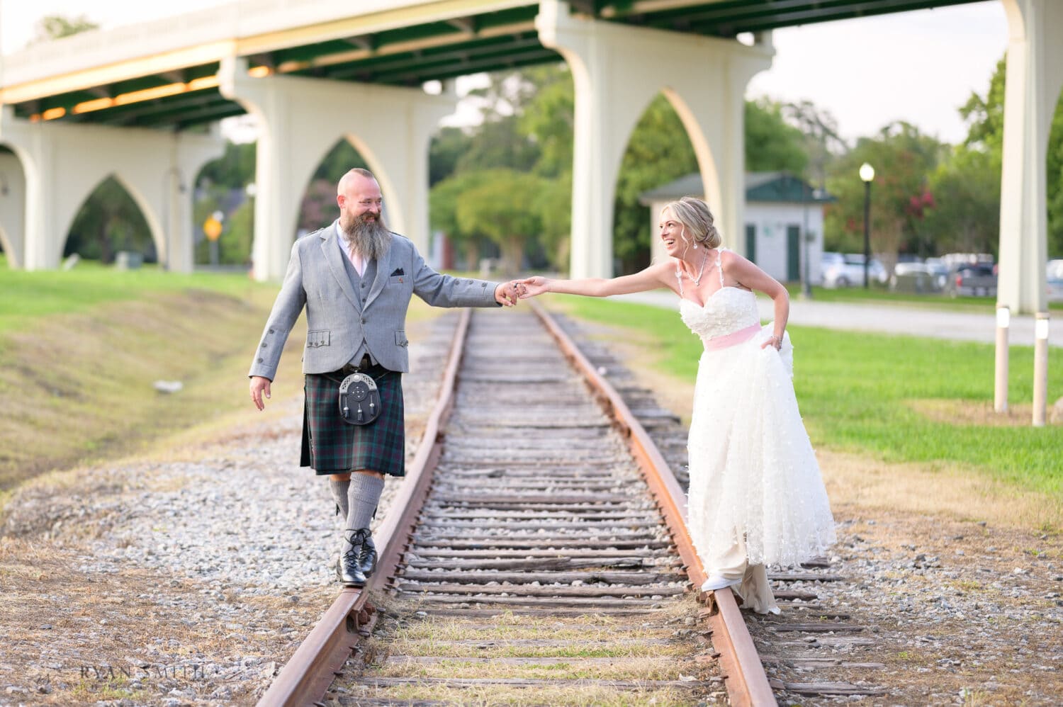 Bride and groom balancing on the tracks - Conway Riverwalk