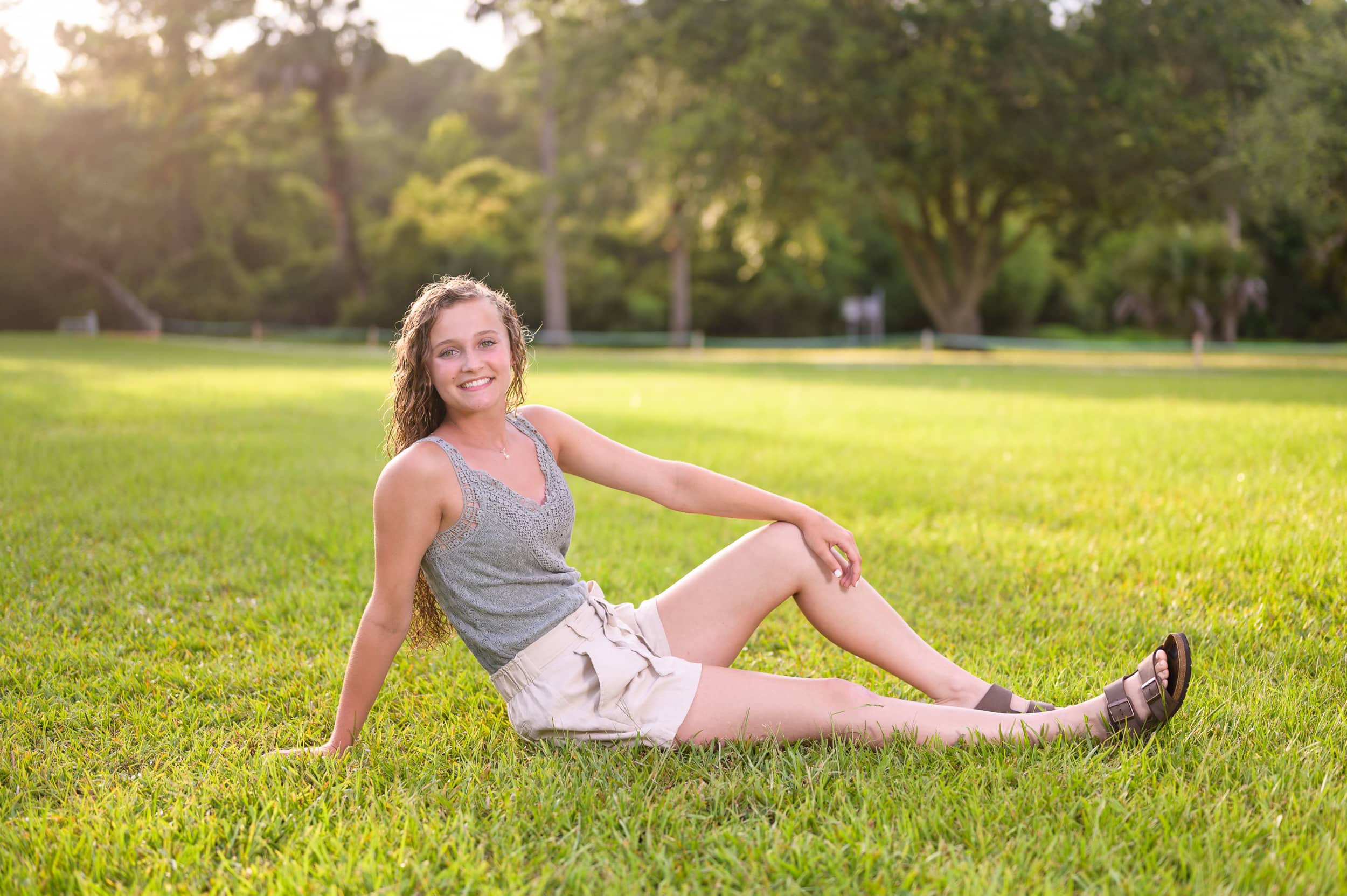 Senior portrait laying in the grass - Huntington Beach State Park