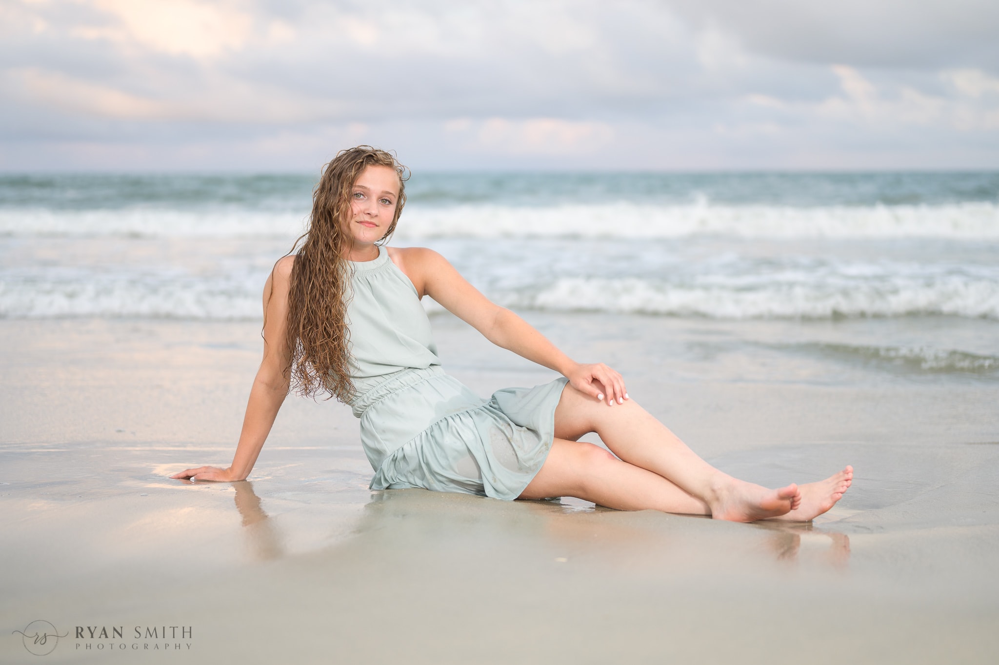 Senior portraits laying by the edge of the ocean - Huntington Beach State Park
