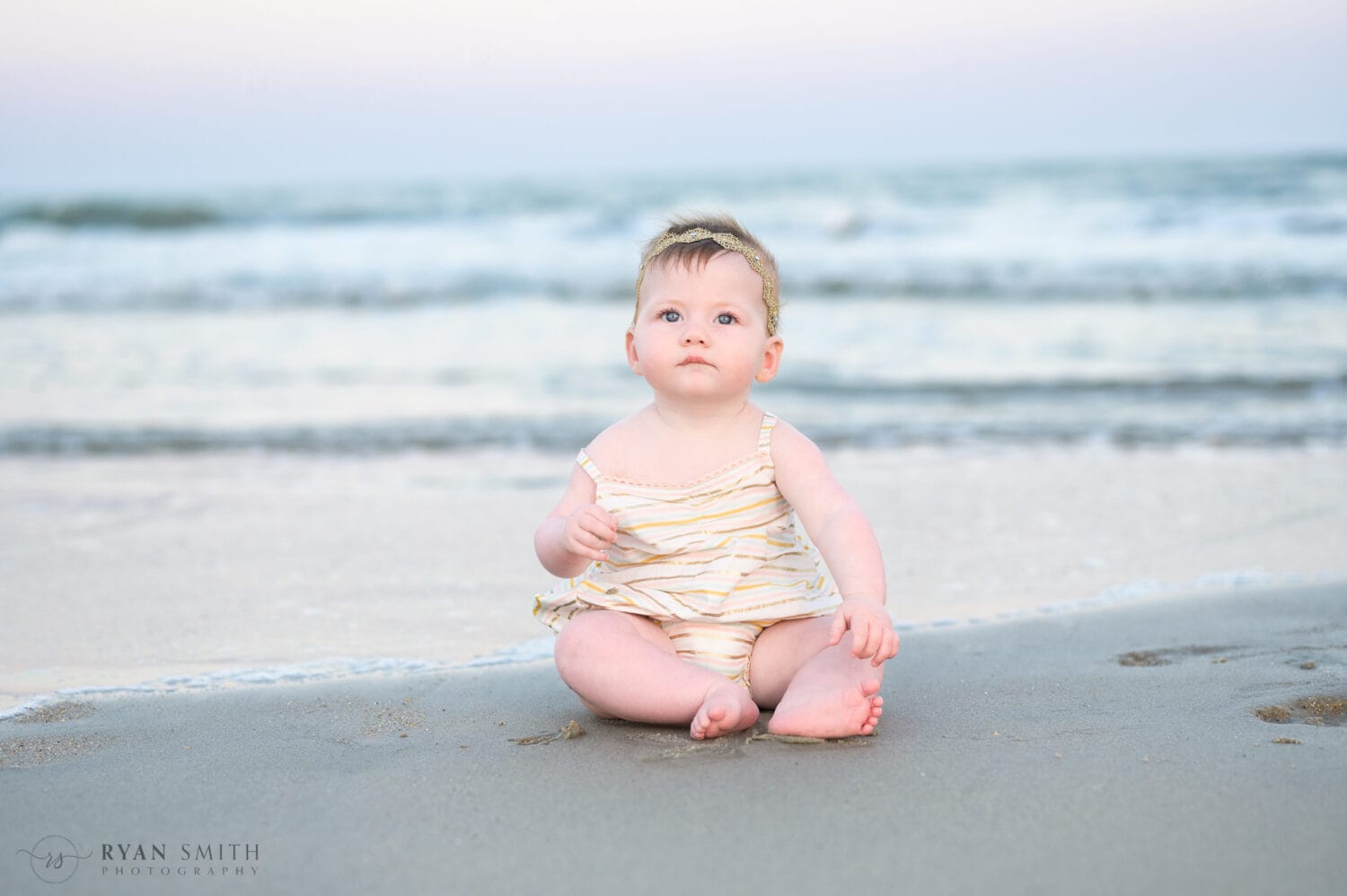 Baby girl sitting by the ocean - Huntington Beach State Park