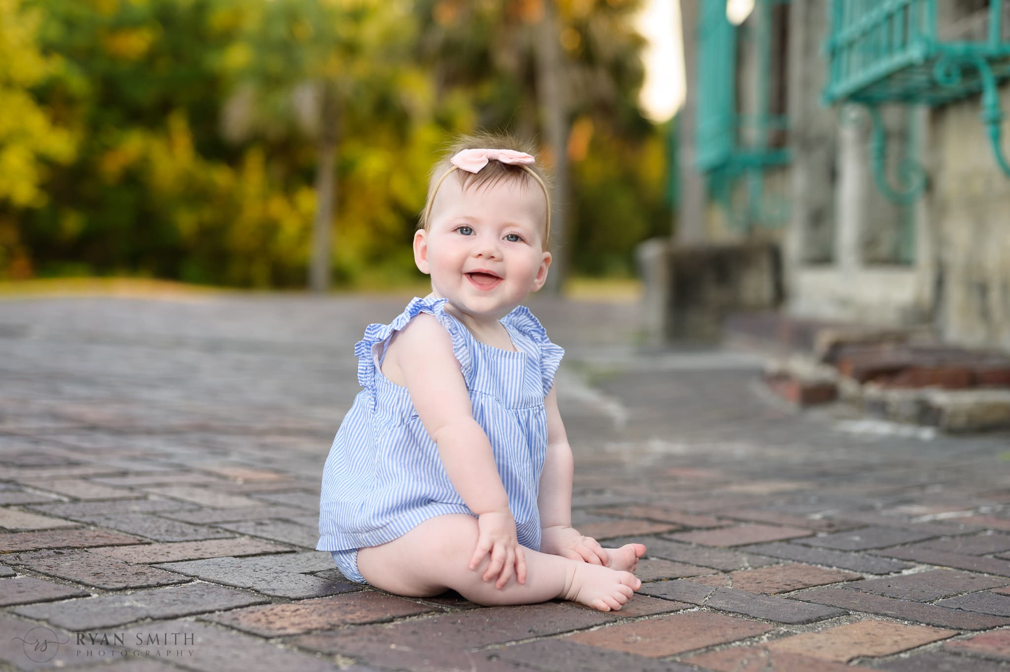 Baby girl sitting on the brick patio behind the Atalaya Castle - Huntington Beach State Park