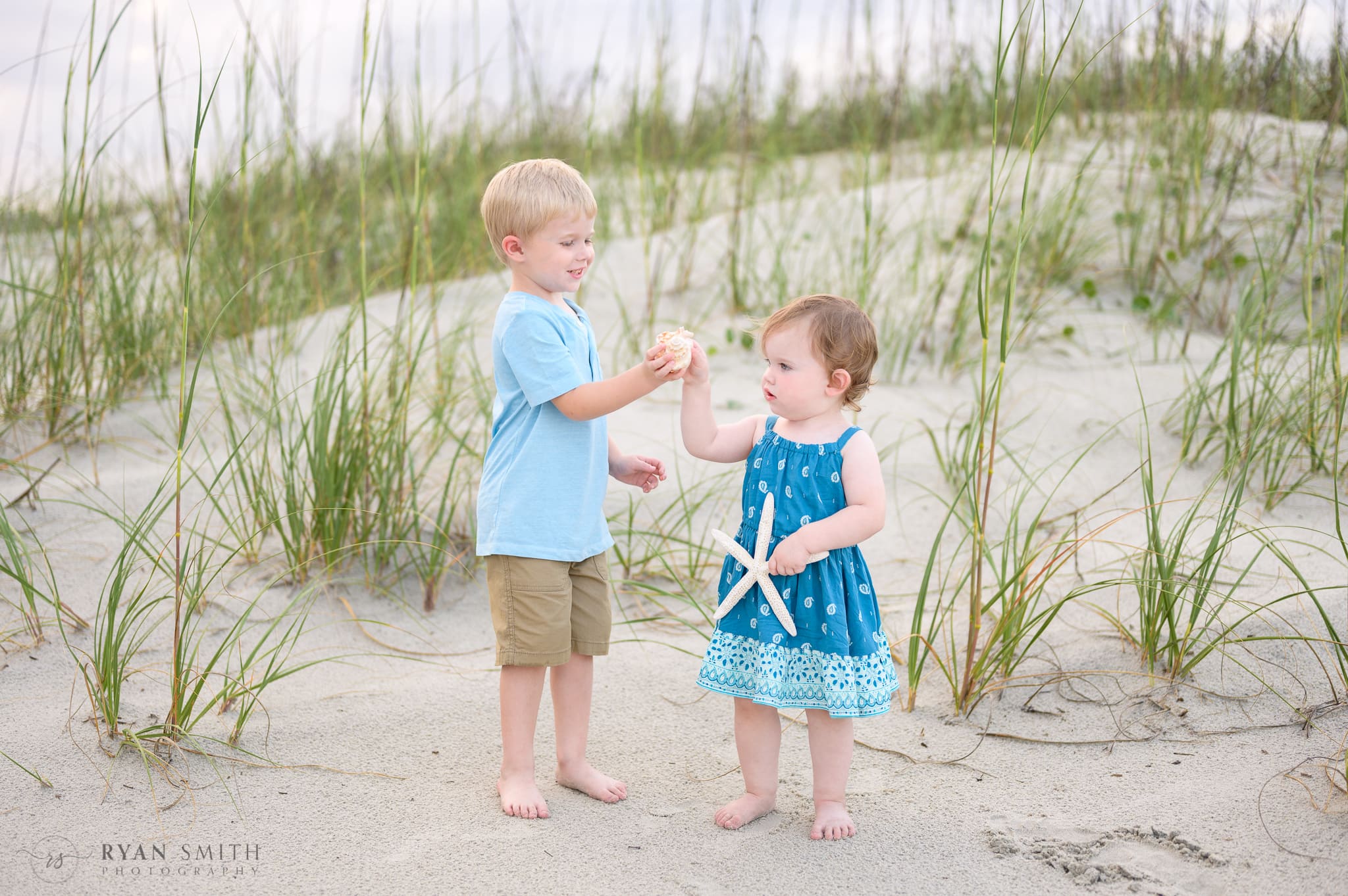 Kids playing with shells together  - Huntington Beach State Park