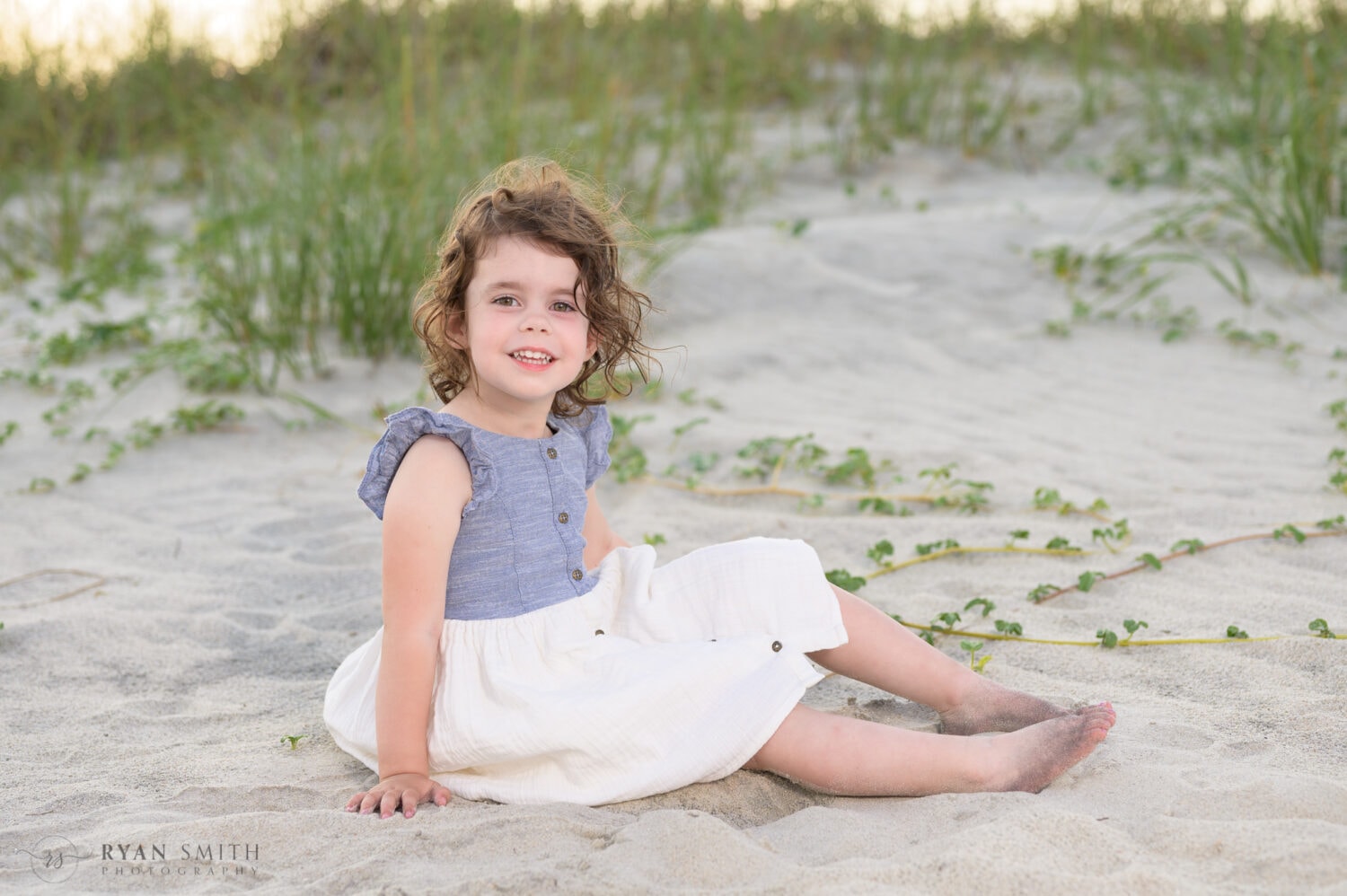 Little girl sitting by the dunes - Huntington Beach State Park