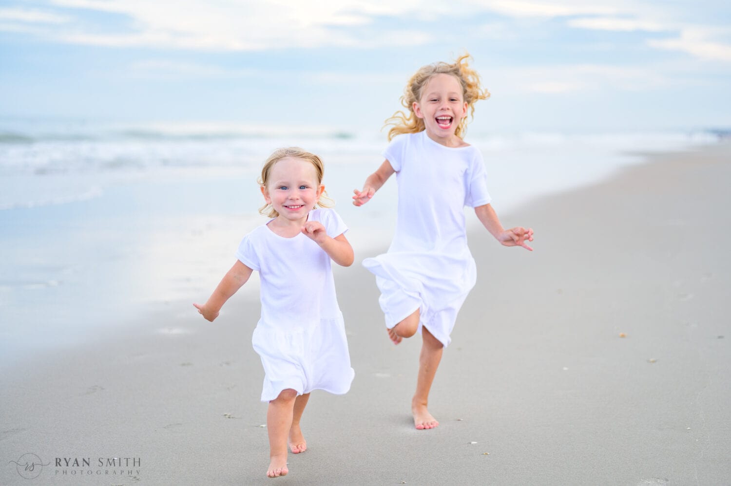 Sisters running down the beach - Huntington Beach State Park