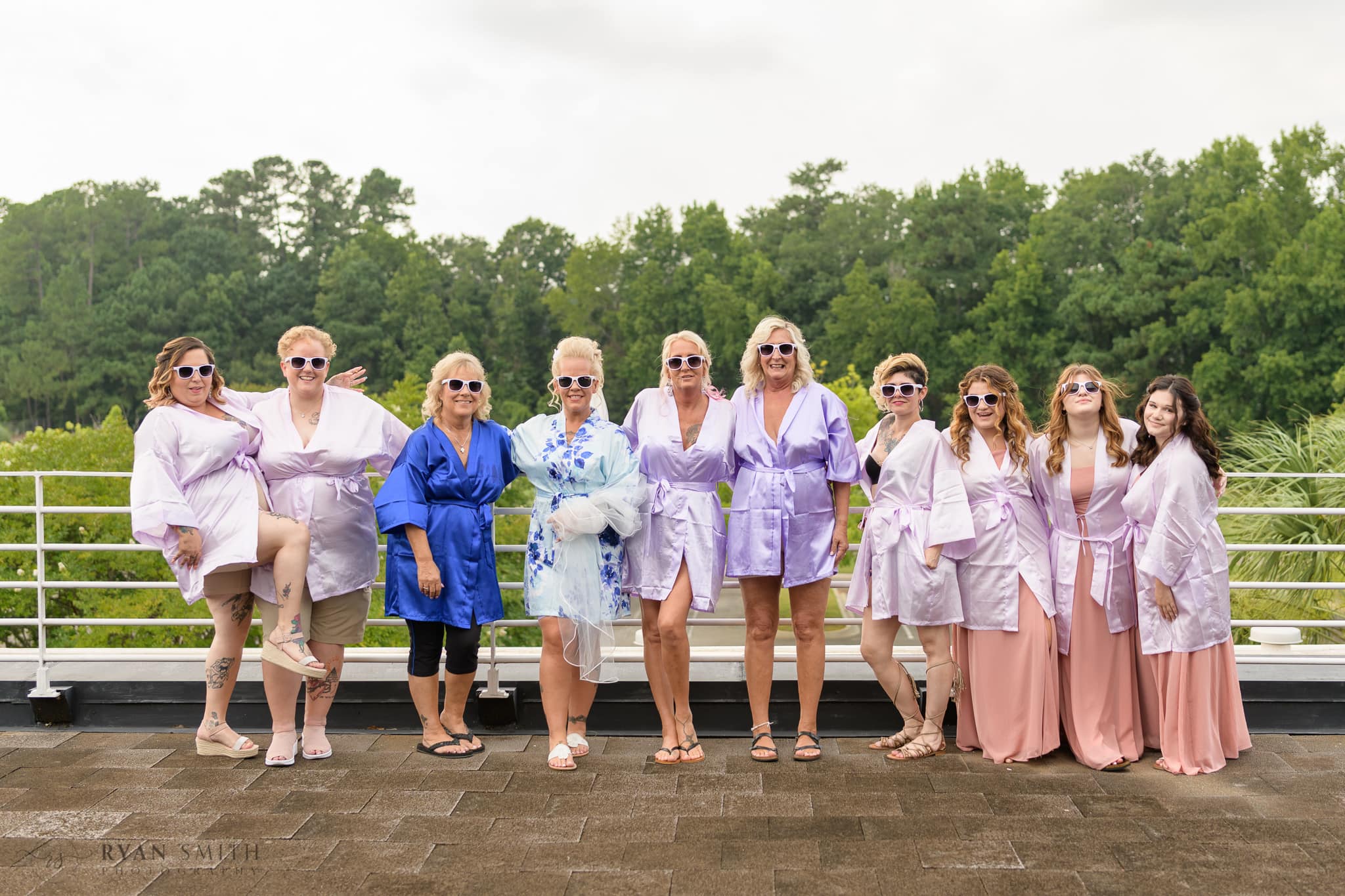Bridesmaids in sunglasses and robes on balcony - Wild Wing Plantation