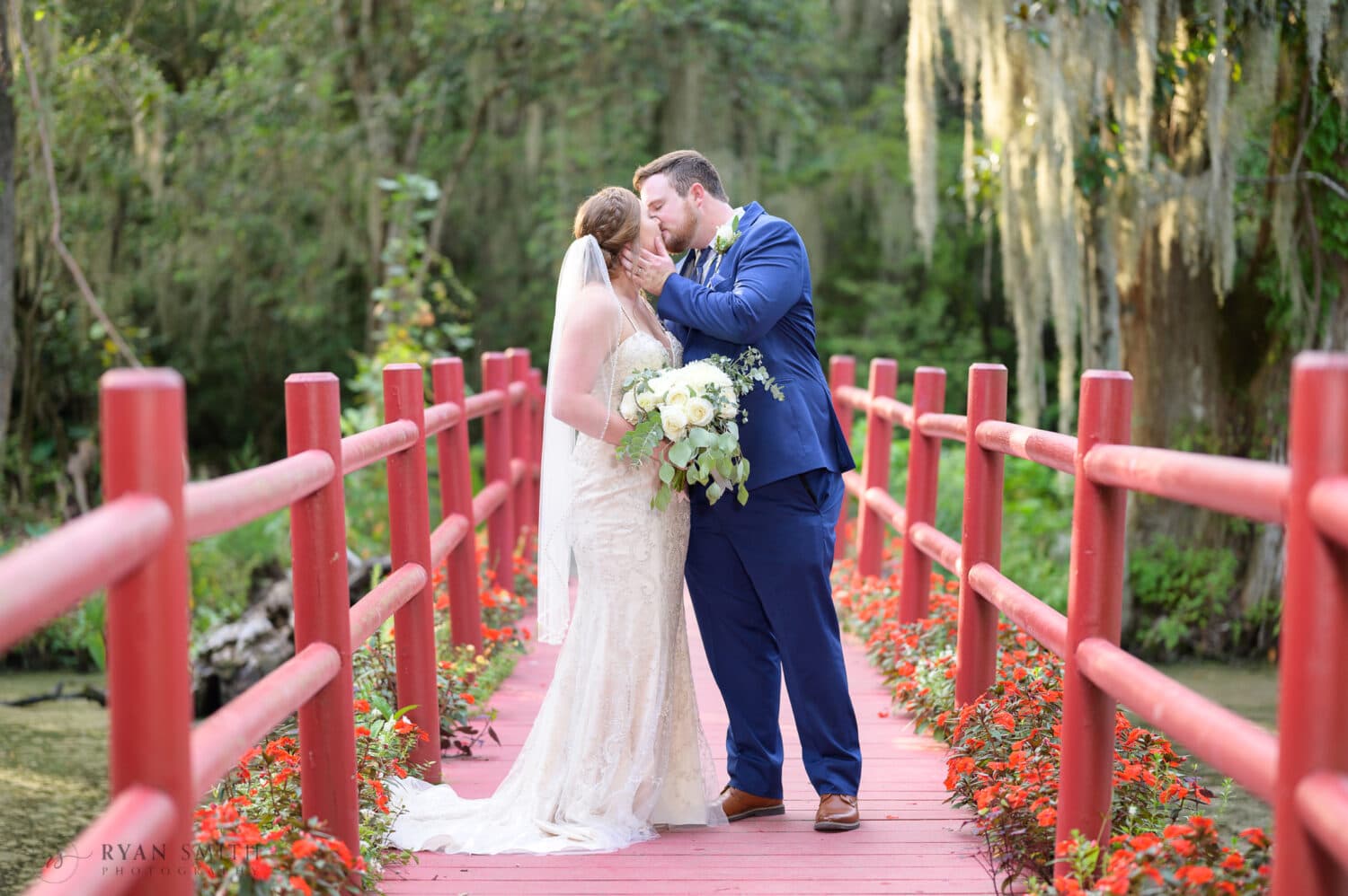 Portraits of the bride and groom on the red bridge - Magnolia Plantation