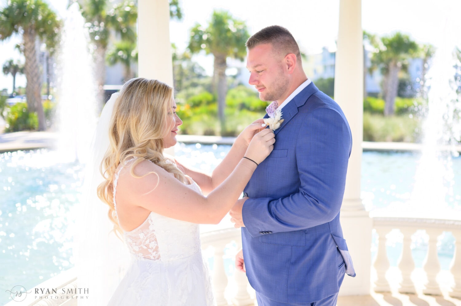 Bride helping groom with his boutonniere  - North Beach Resort & Villas