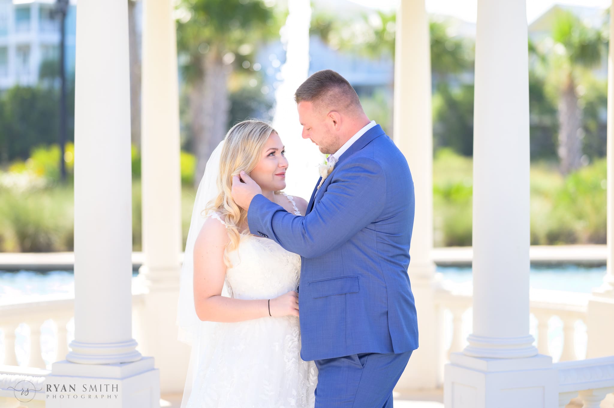 Groom pushing back bride's hair for a kiss - North Beach Resort & Villas