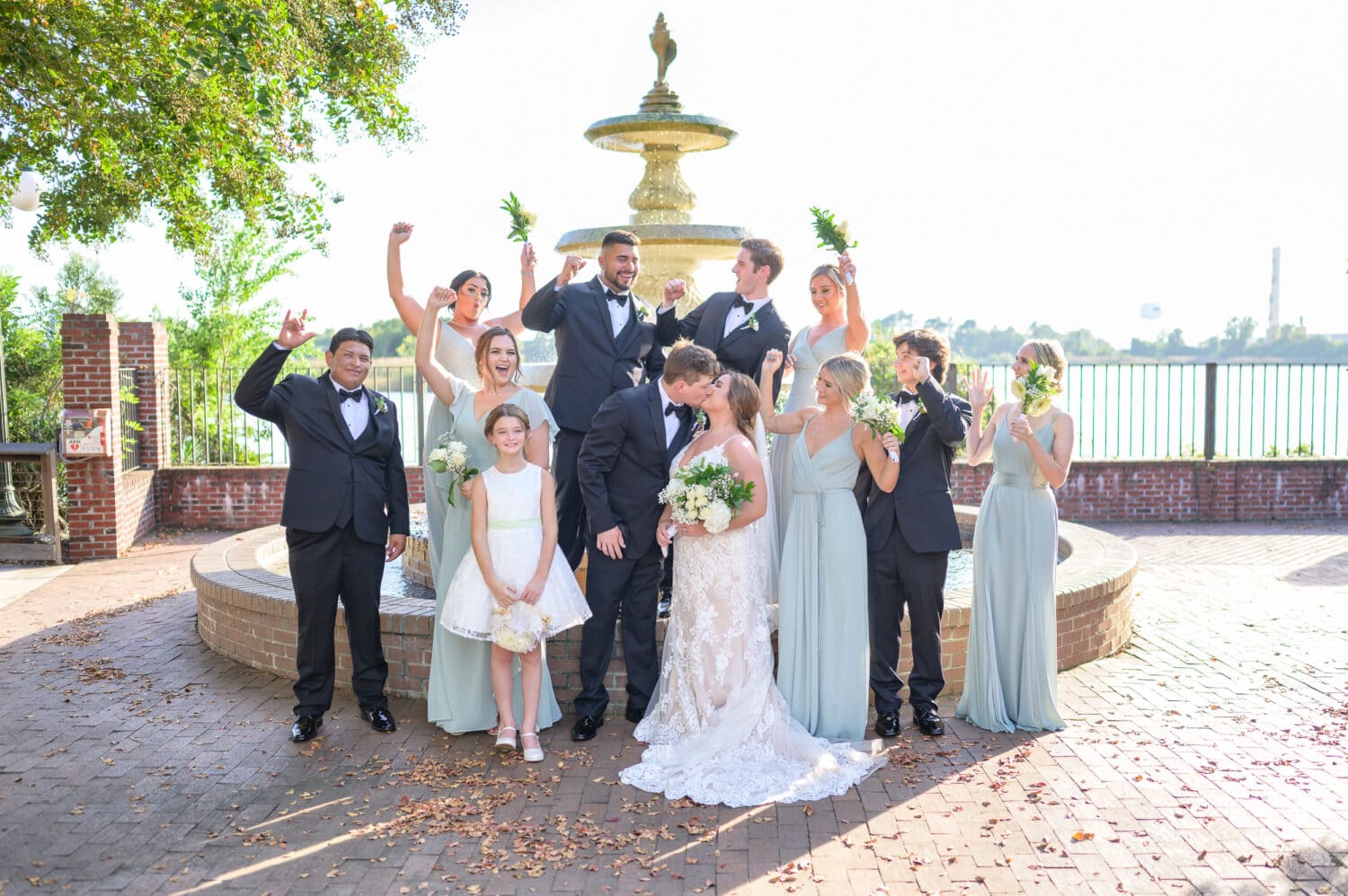 Groomsmen and bridesmaids cheering for bride and groom while they kiss - Kaminski House Museum