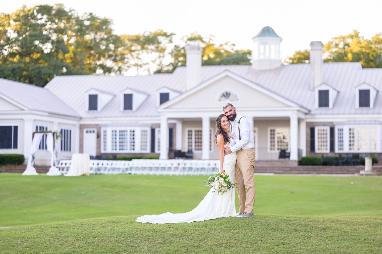 Bride and groom with clubhouse in the background - Pawleys Plantation Golf & Country Club