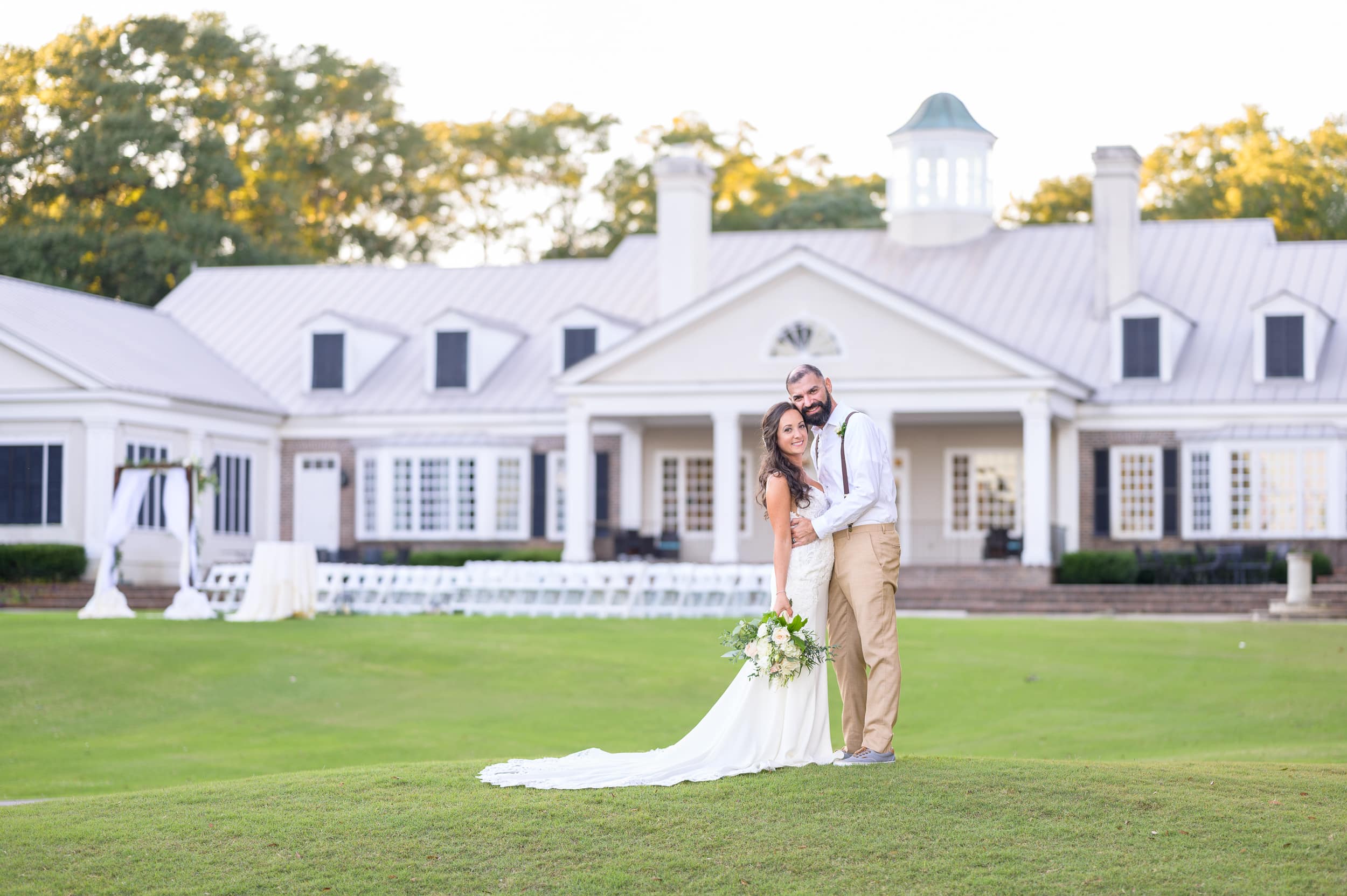 Bride and groom with clubhouse in the background - Pawleys Plantation