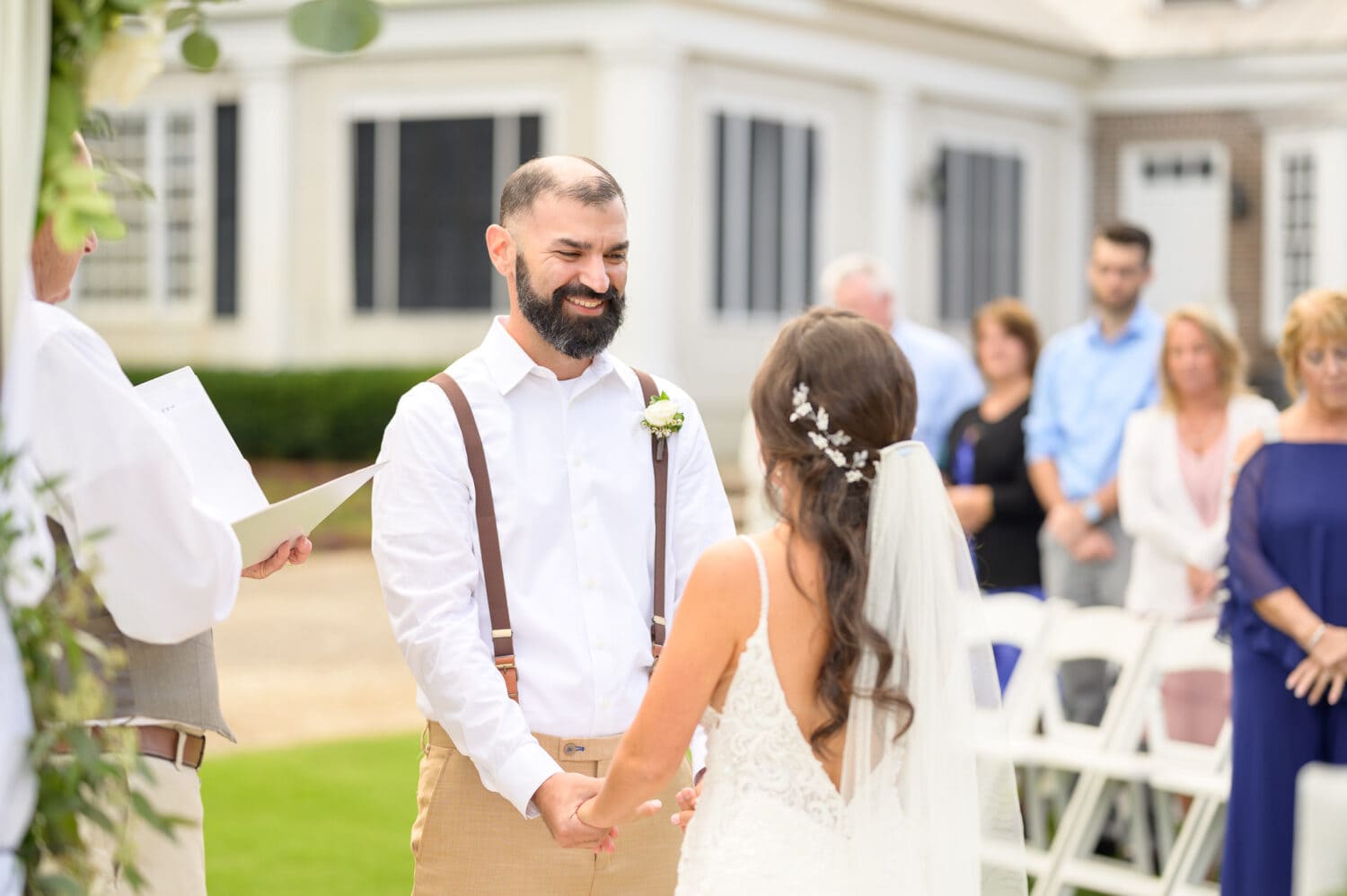 Groom smiling at bride during the ceremony - Pawleys Plantation