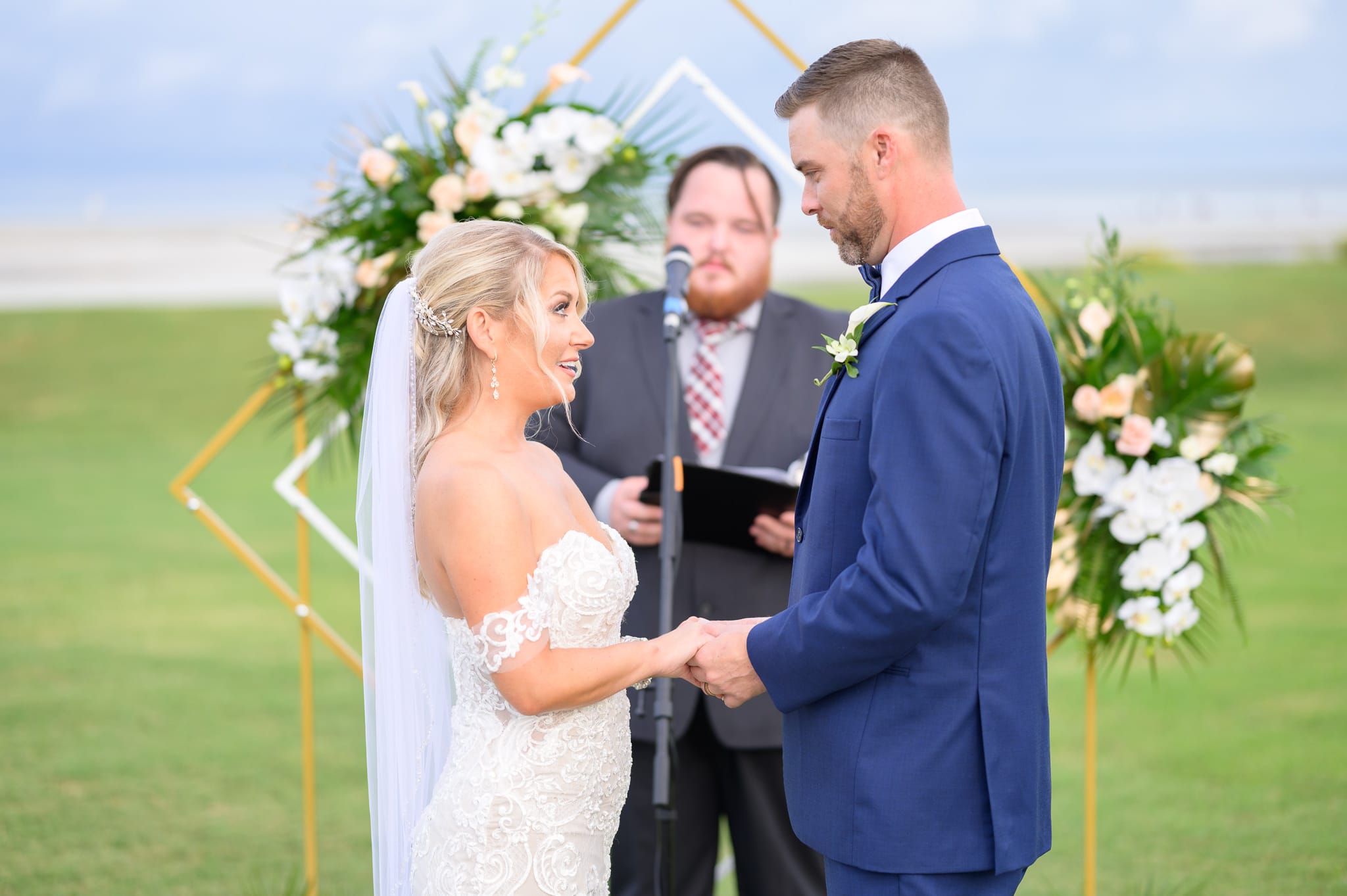 Holding hands during vows - Dunes Golf and Beach Club
