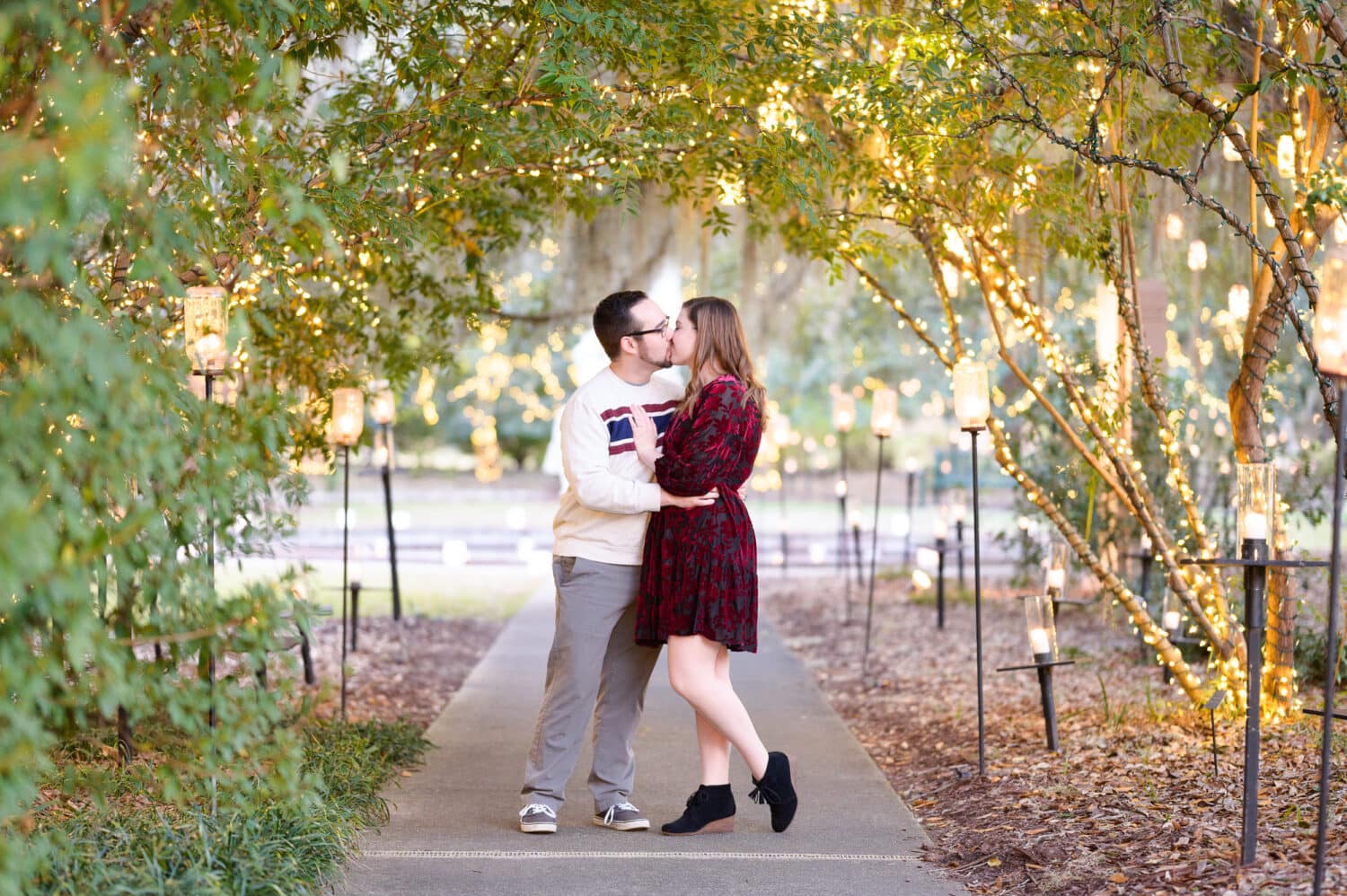 Kiss on the walkway surrounded by lights -