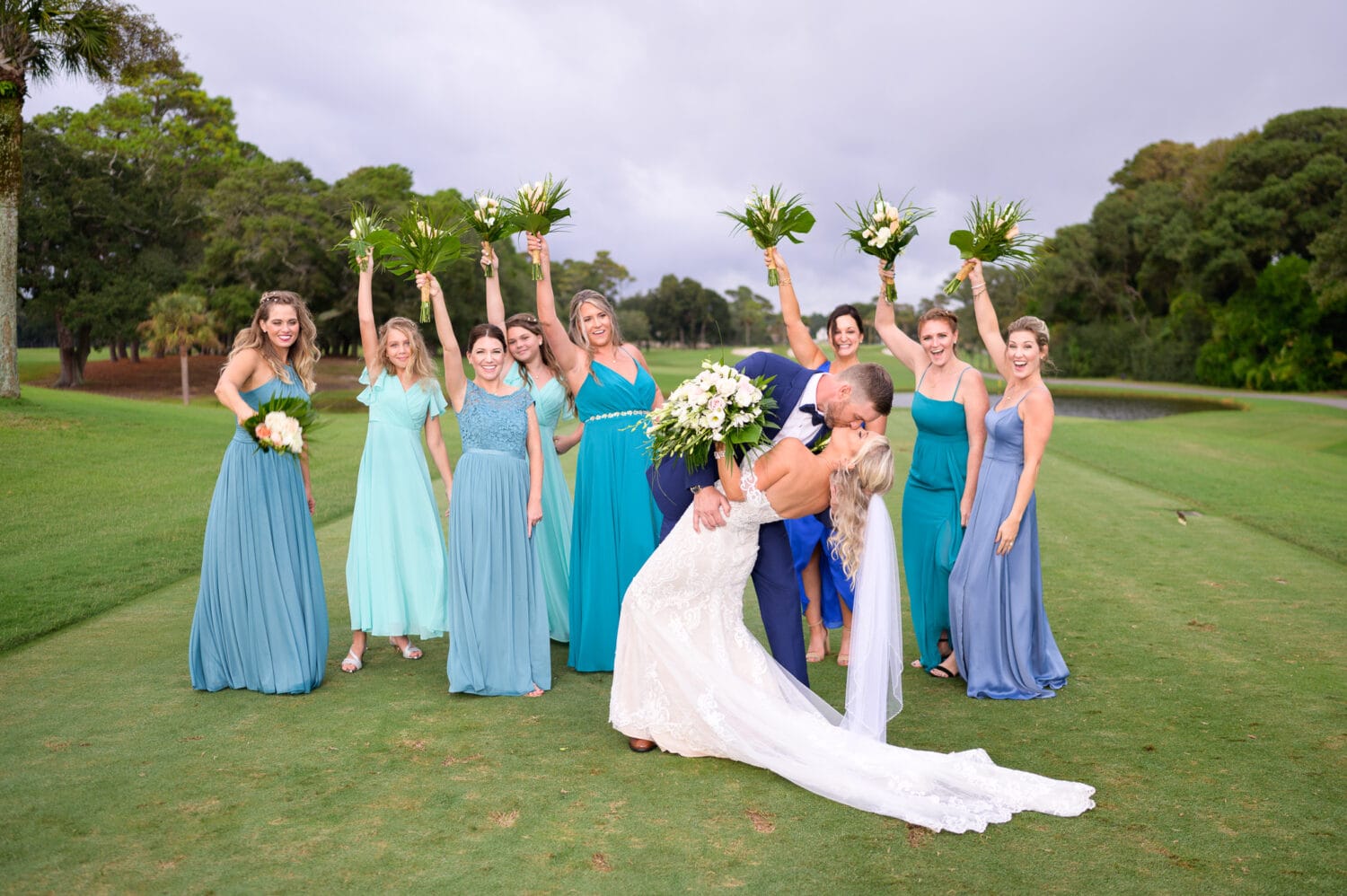 Kiss with bridesmaids cheering in the background - Dunes Golf and Beach Club