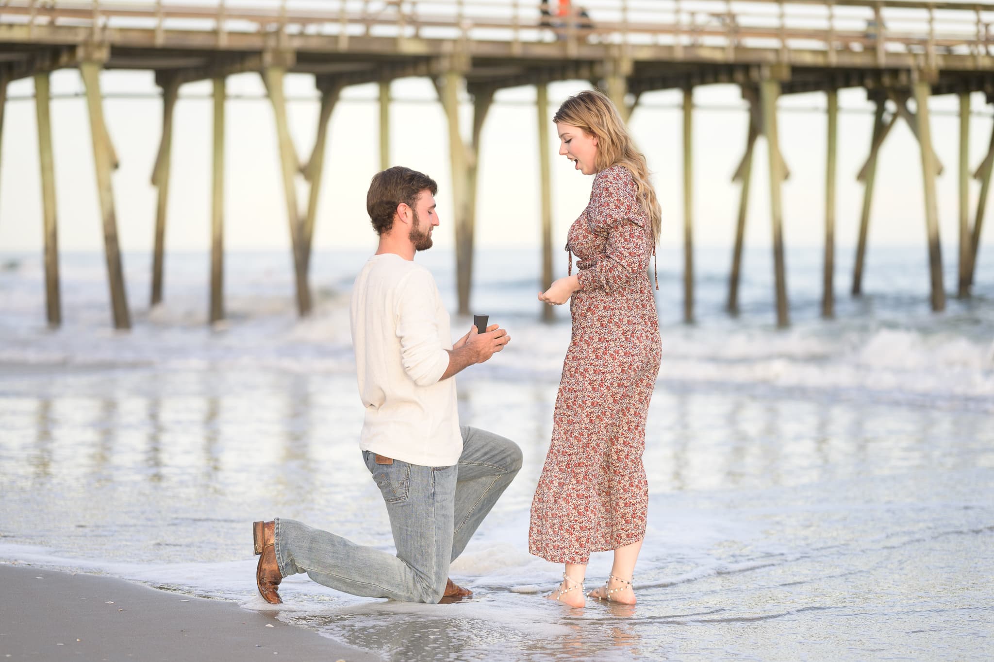 Getting down on a knee for surprise proposal by the pier - Myrtle Beach State Park