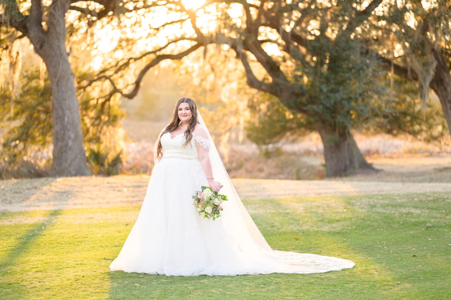 Bride in front of the marsh with sunlight filtering through the trees - Pawleys Plantation Golf & Country Club
