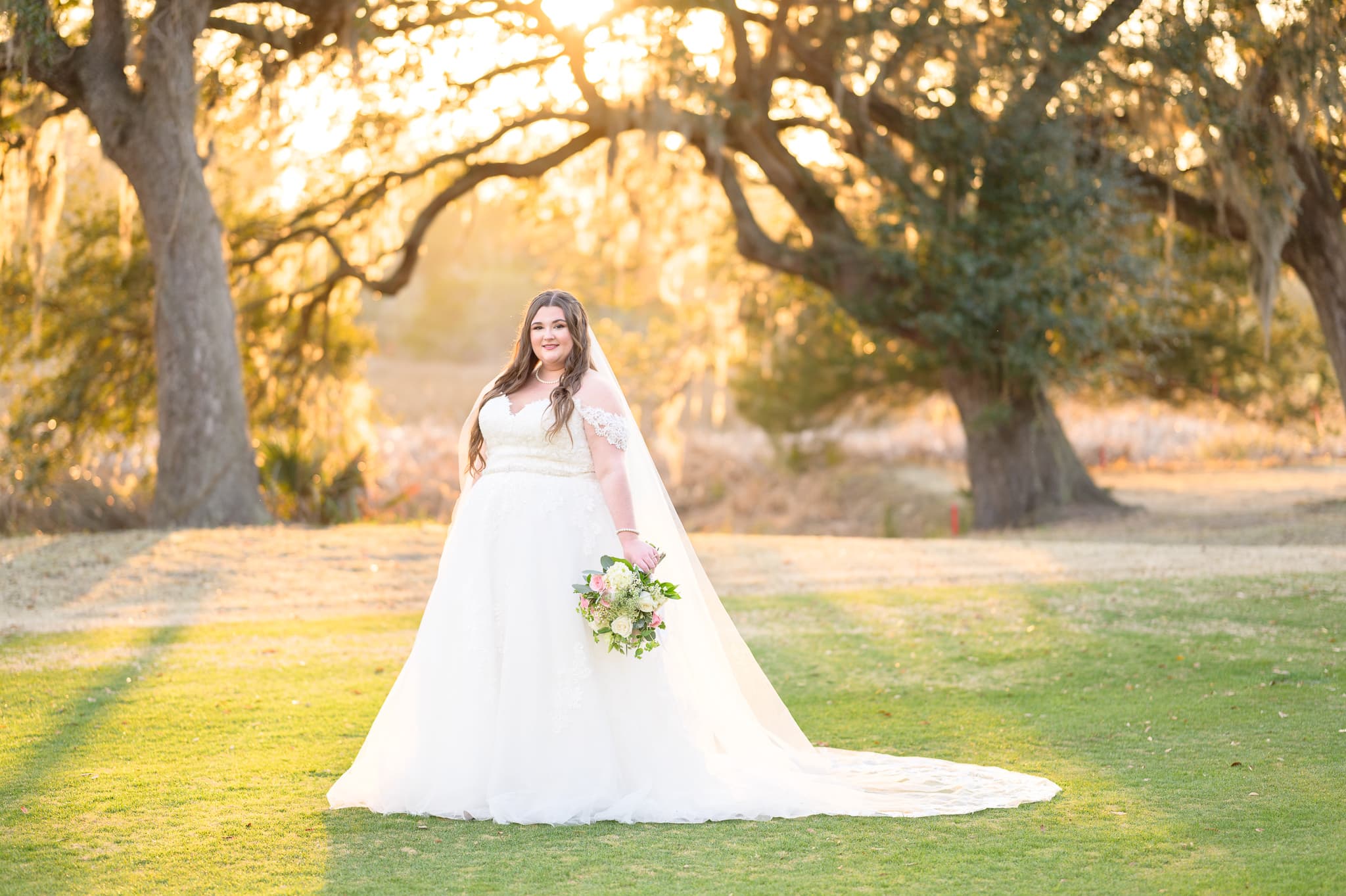 Bride in front of the marsh with sunlight filtering through the trees - Pawleys Plantation Golf & Country Club