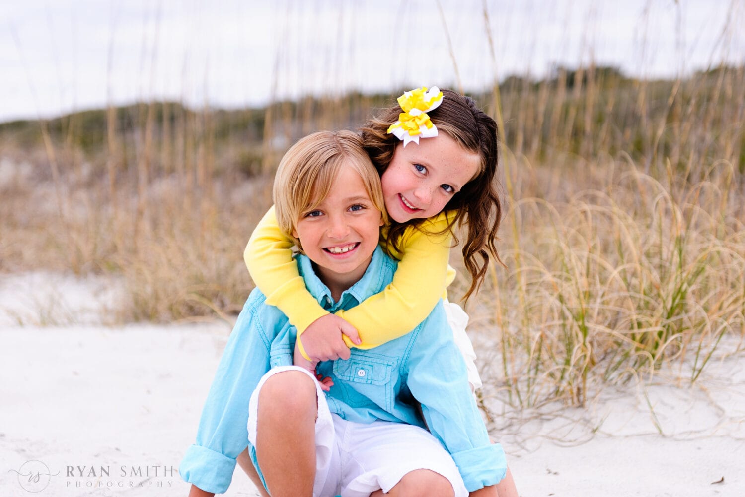 Brother getting a big hug from his little sister in front of the dunes - Myrtle Beach State Park
