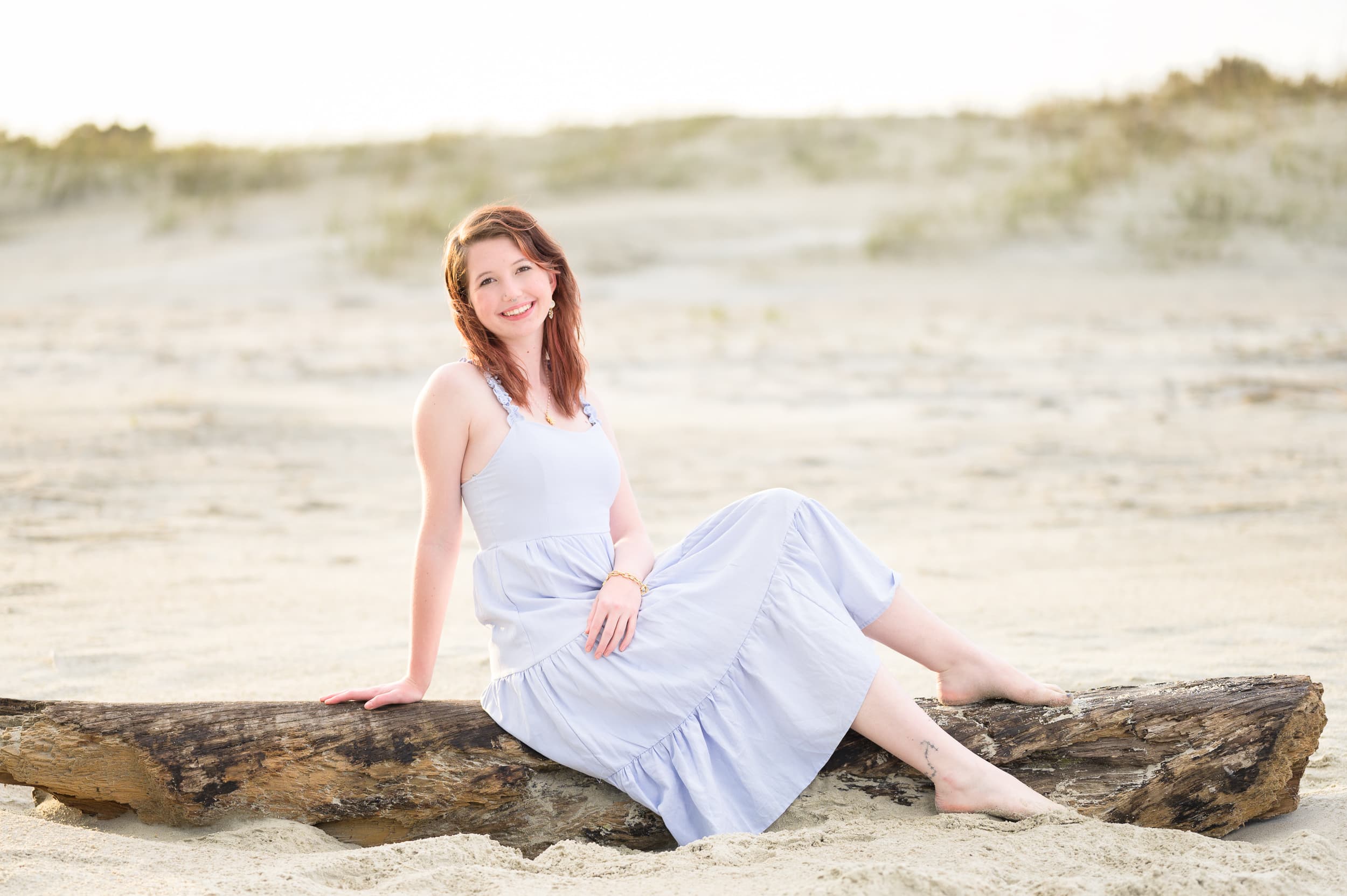 Senior girl sitting on beach driftwood - Pawleys Island