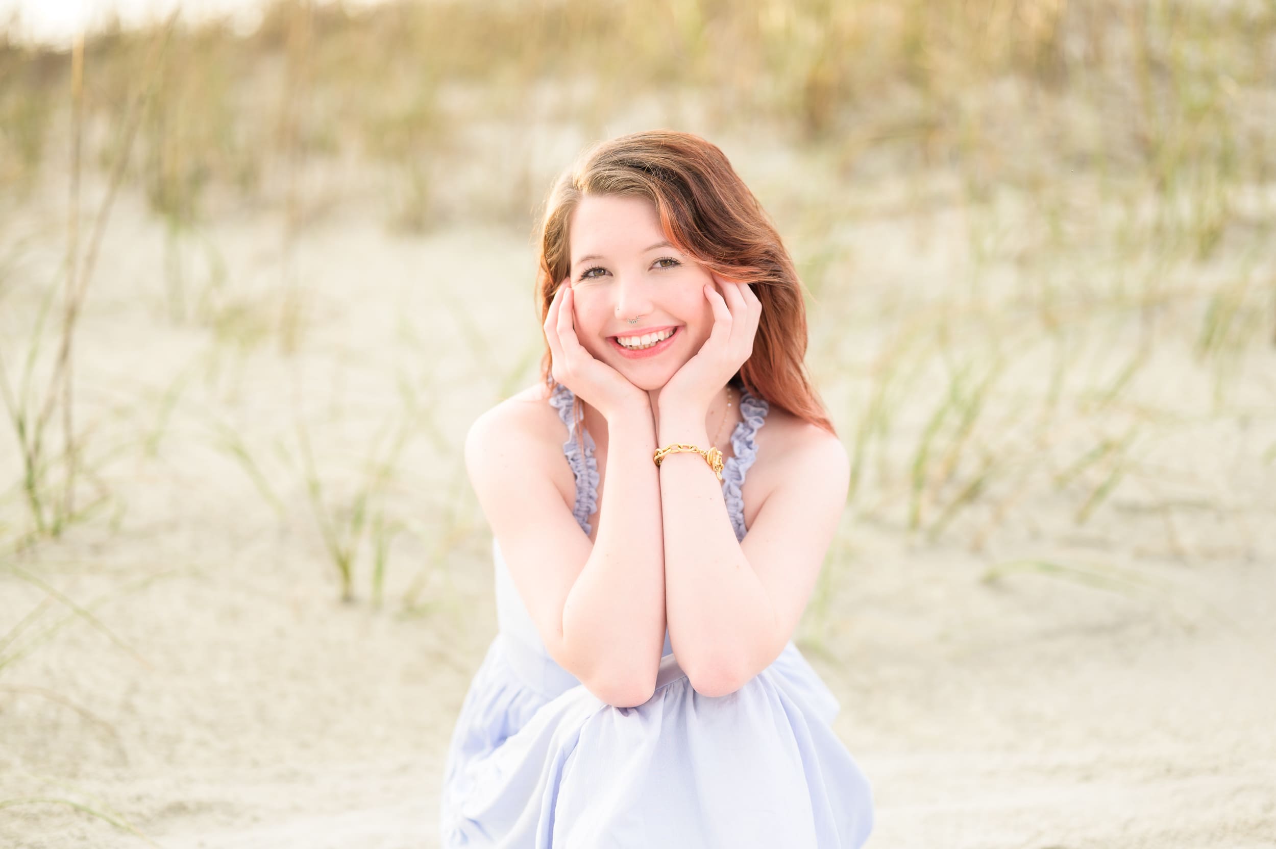 Senior portrait sitting in the sand with hands framing the face - Pawleys Island