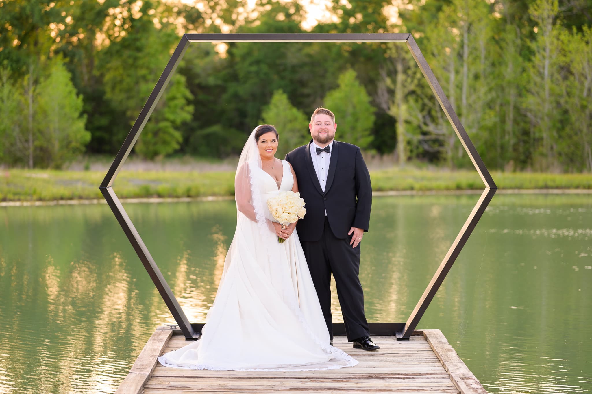 Bride and groom in front of the octagon on the lake - The Venue at White Oaks Farm