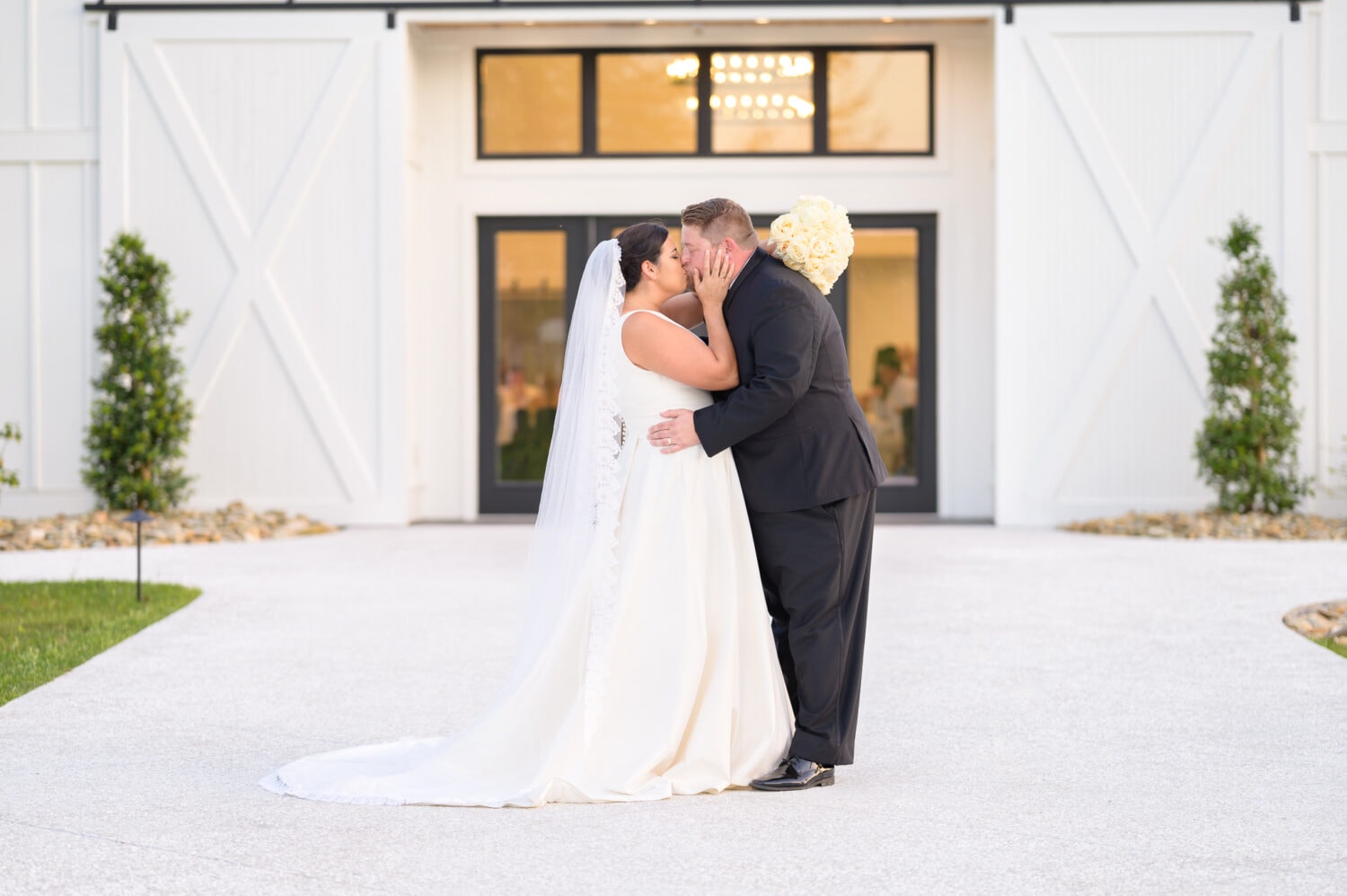 Kiss in front of the black doors - The Venue at White Oaks Farm