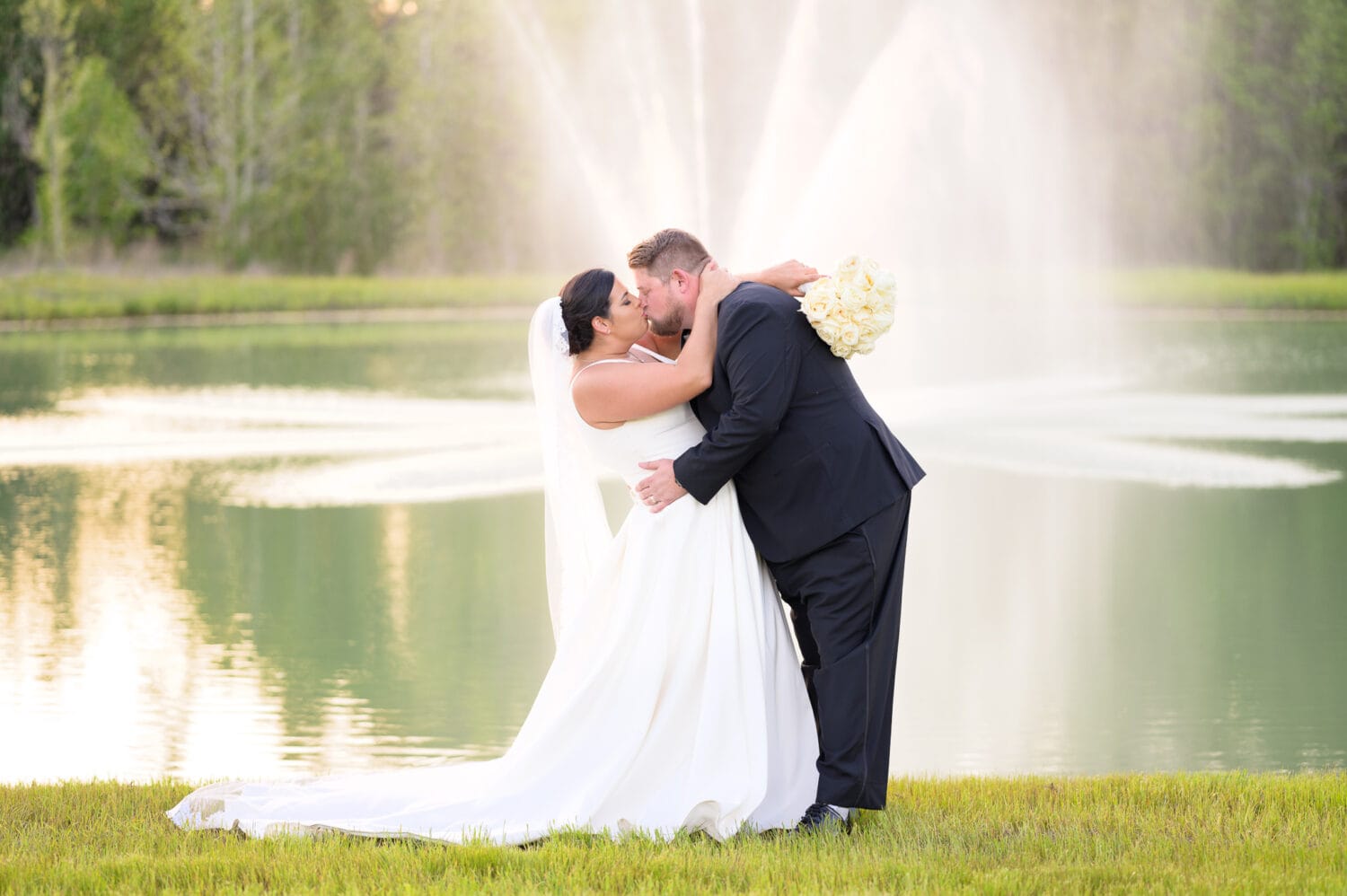 Kiss in front of the fountain - The Venue at White Oaks Farm