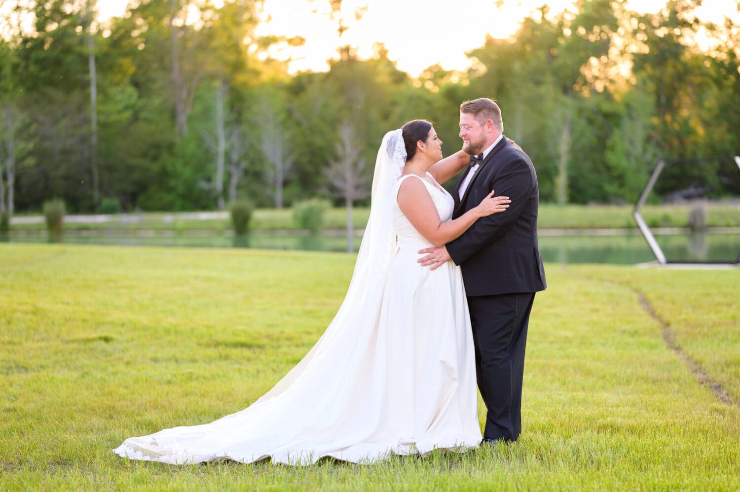 Portraits of bride and groom in the sunset by the lake - The Venue at White Oaks Farm