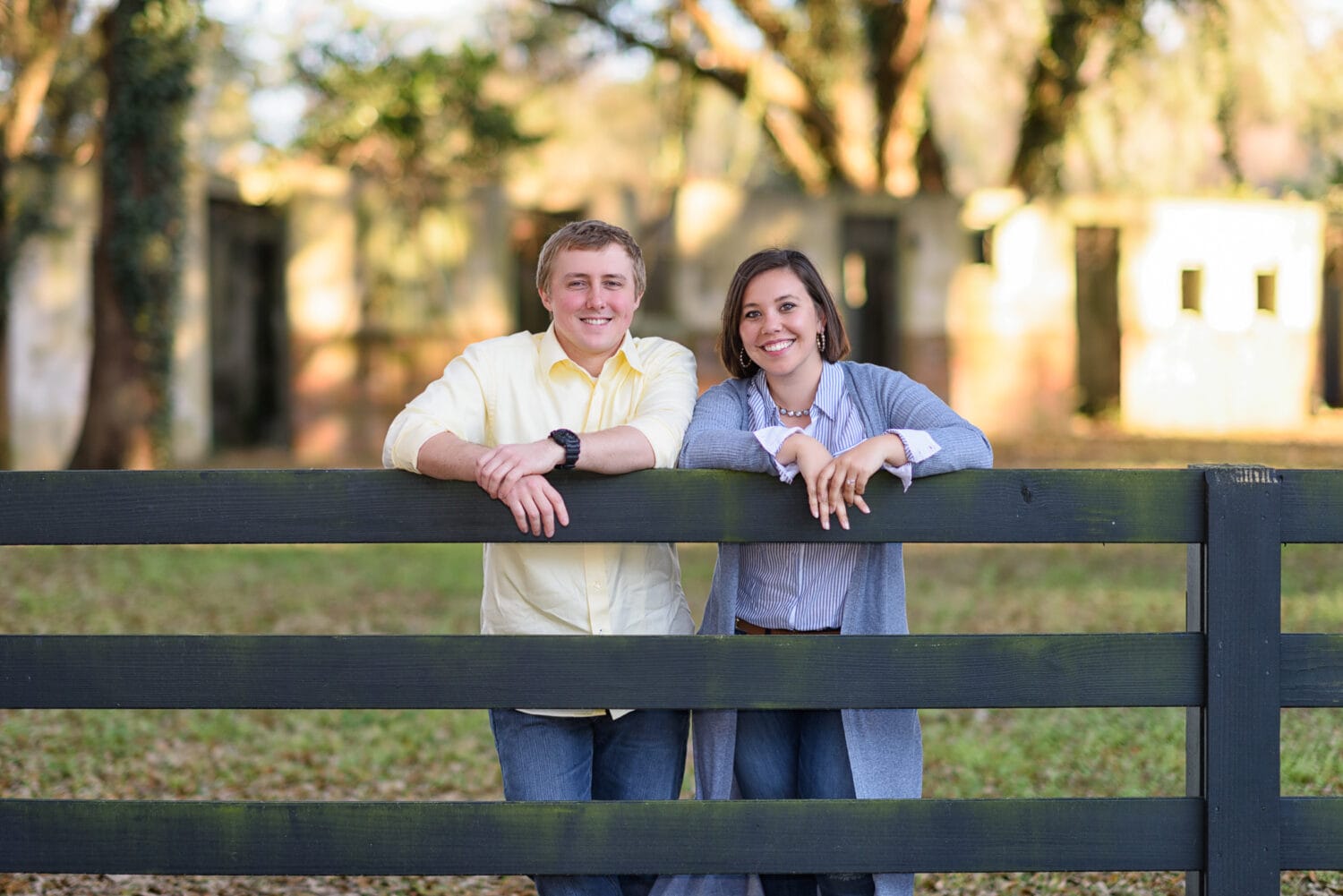 Engaged couple hanging out on a fence in front of the old hotel - Pawleys Island