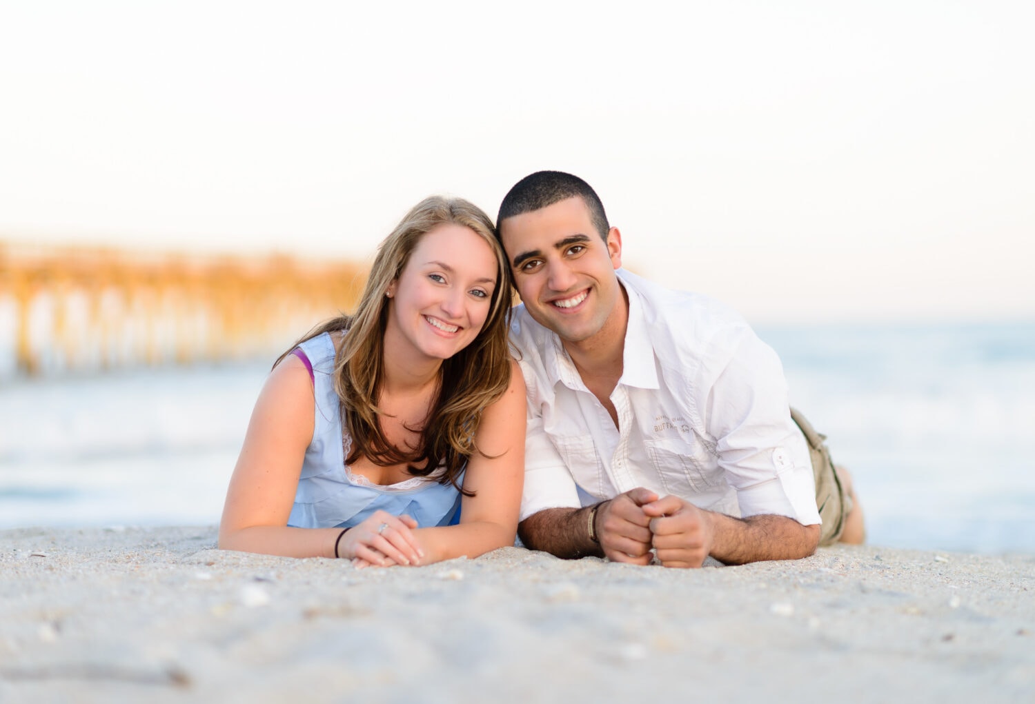 Engaged couple laying together in the sand - Myrtle Beach State Park