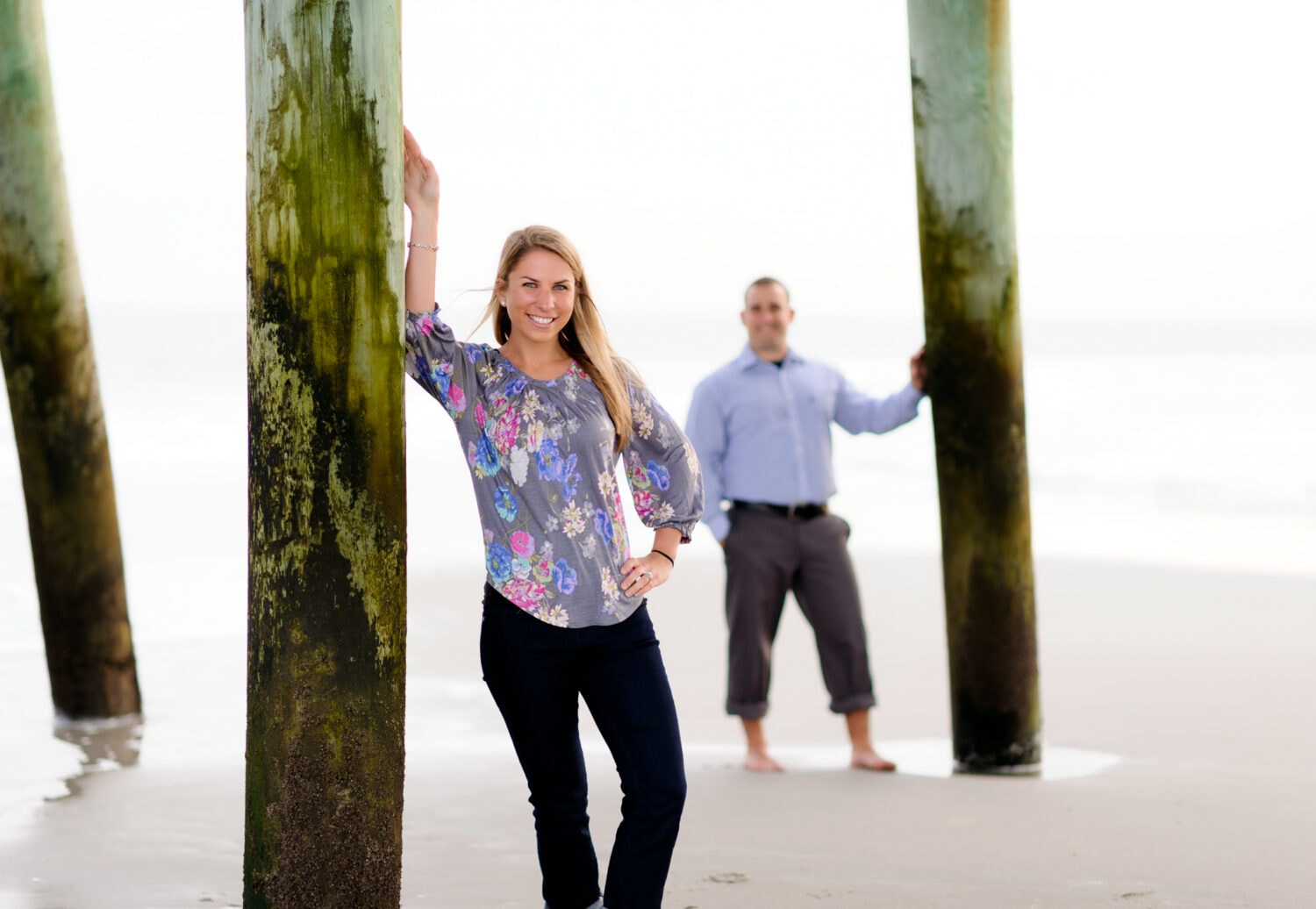Girl in focus with guy in the background by pier - Myrtle Beach State Park