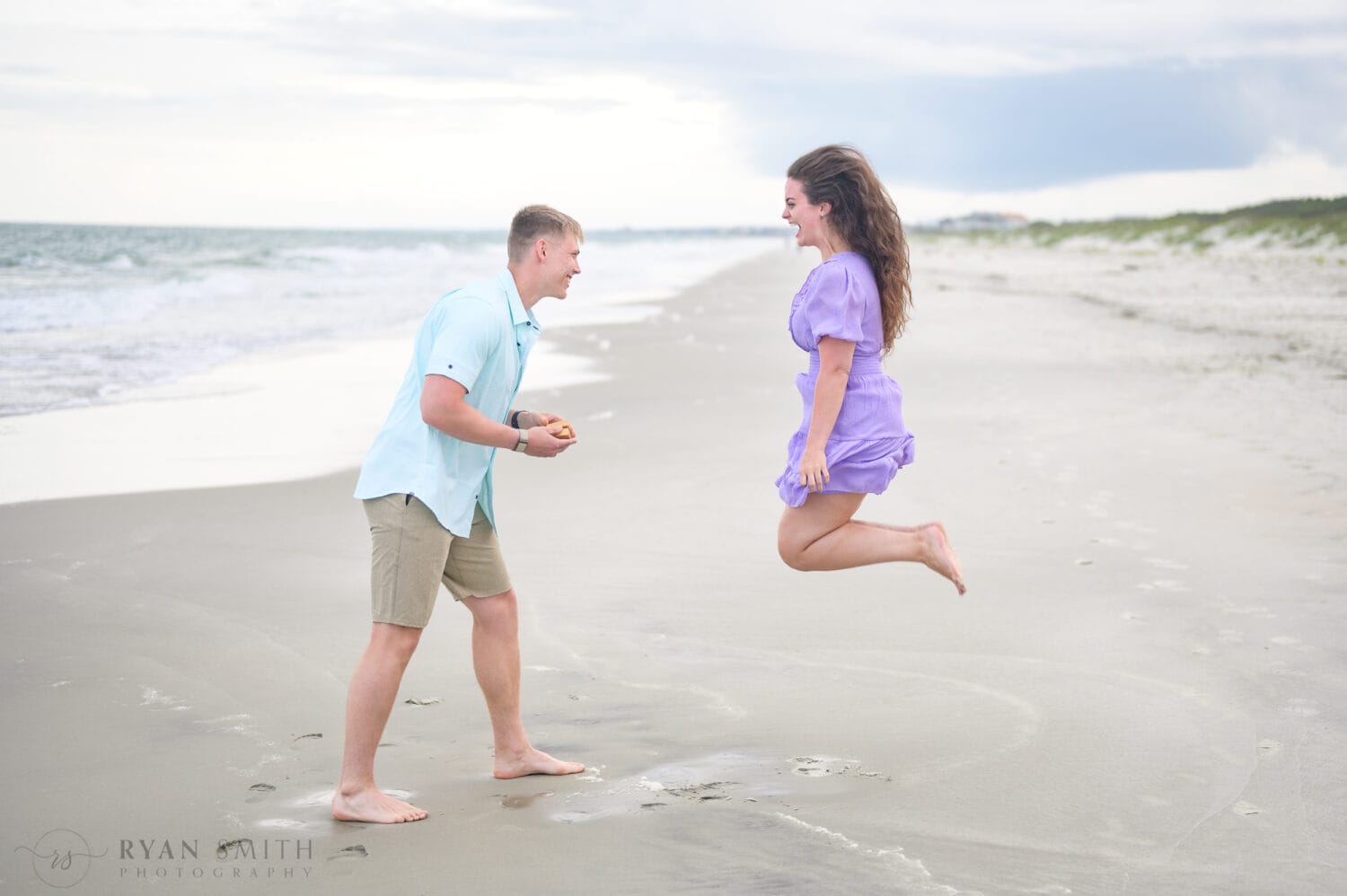 Jumping for joy during the surprise proposal - Huntington Beach State Park