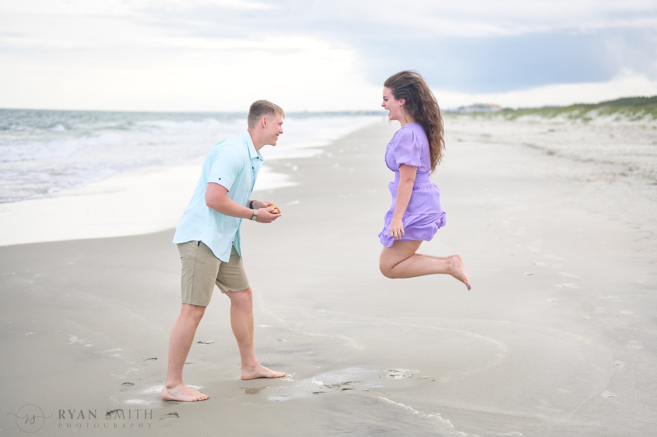 Jumping for joy during the surprise proposal - Huntington Beach State Park