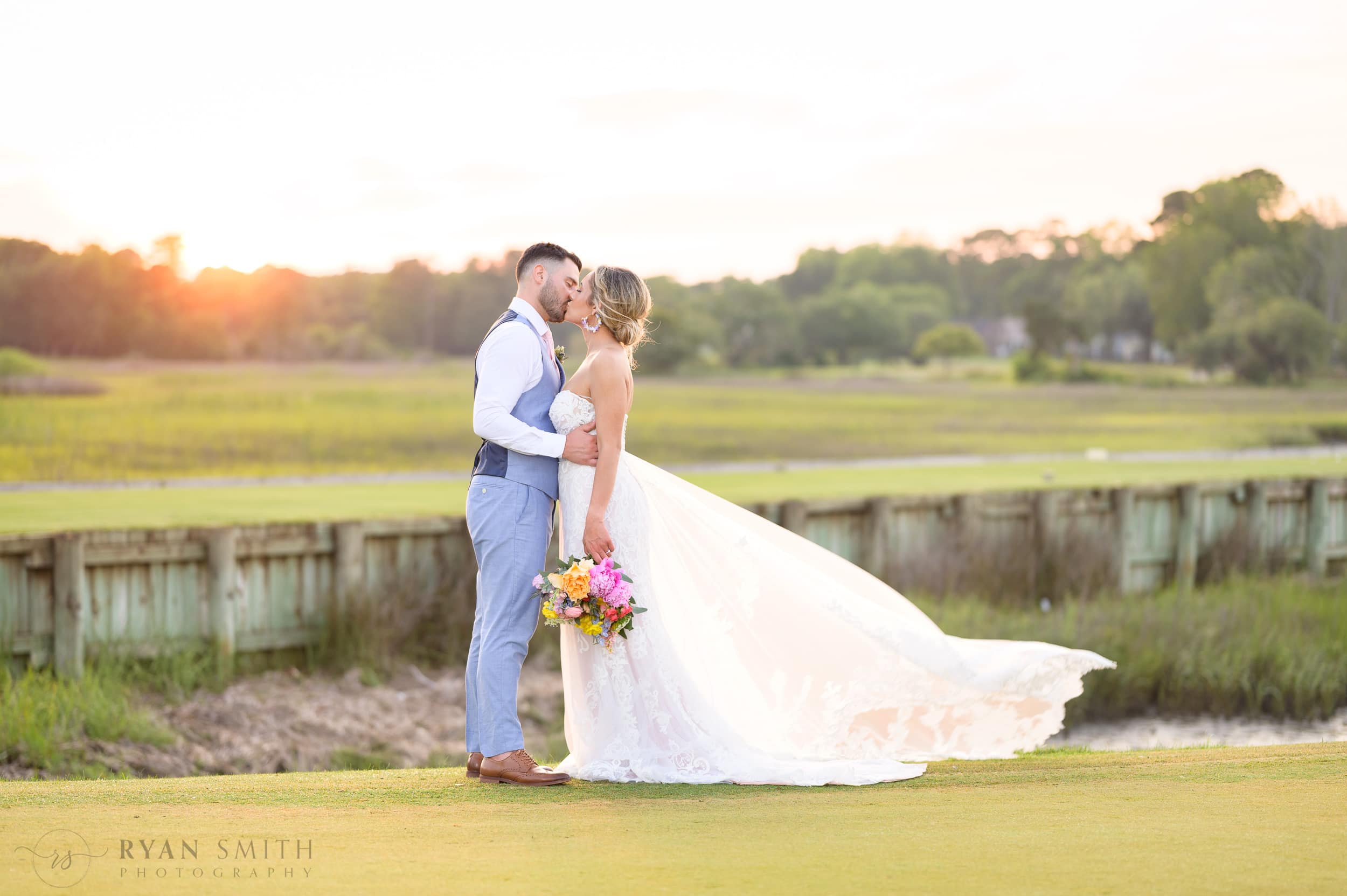 Pawleys Plantation wedding with beautiful flowers, a trolly, and a great sunset on the golf course