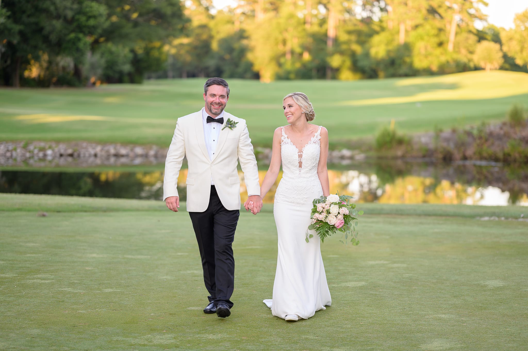 Bride and groom walking down the golf course - Caledonia Golf & Fish Club