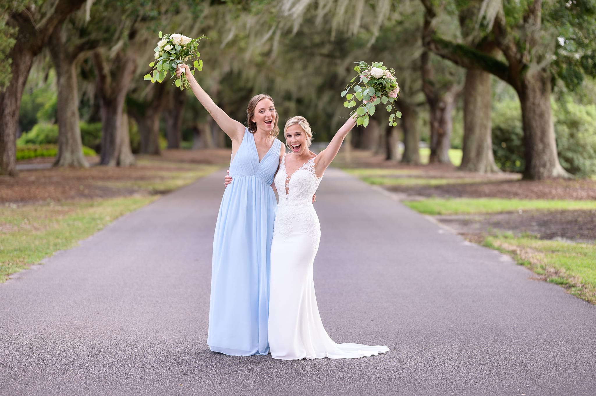 Bride and maid of honor holding flowers in the air - Caledonia Golf & Fish Club