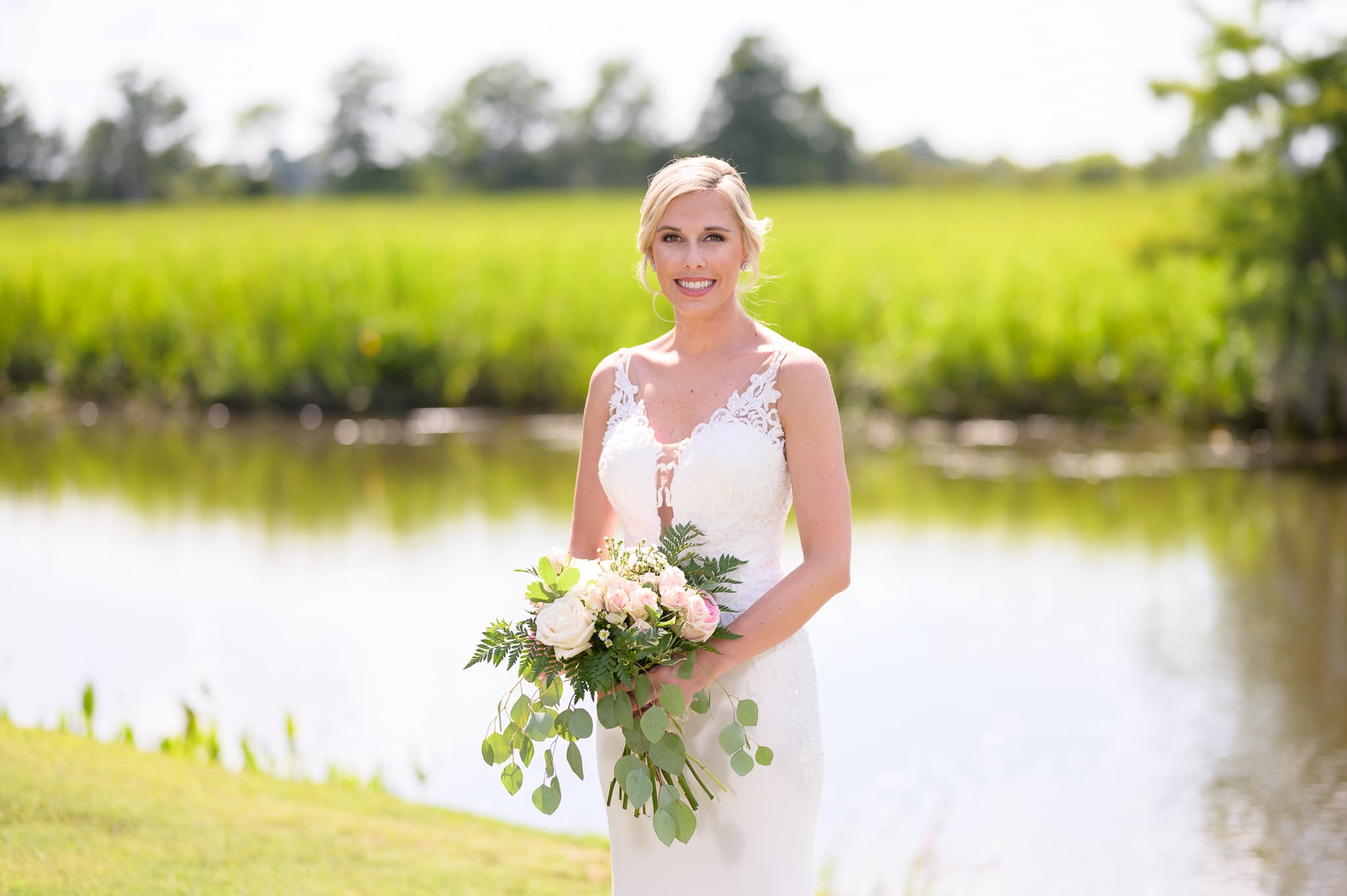 Bride by the water behind the clubhouse - Caledonia Golf & Fish Club