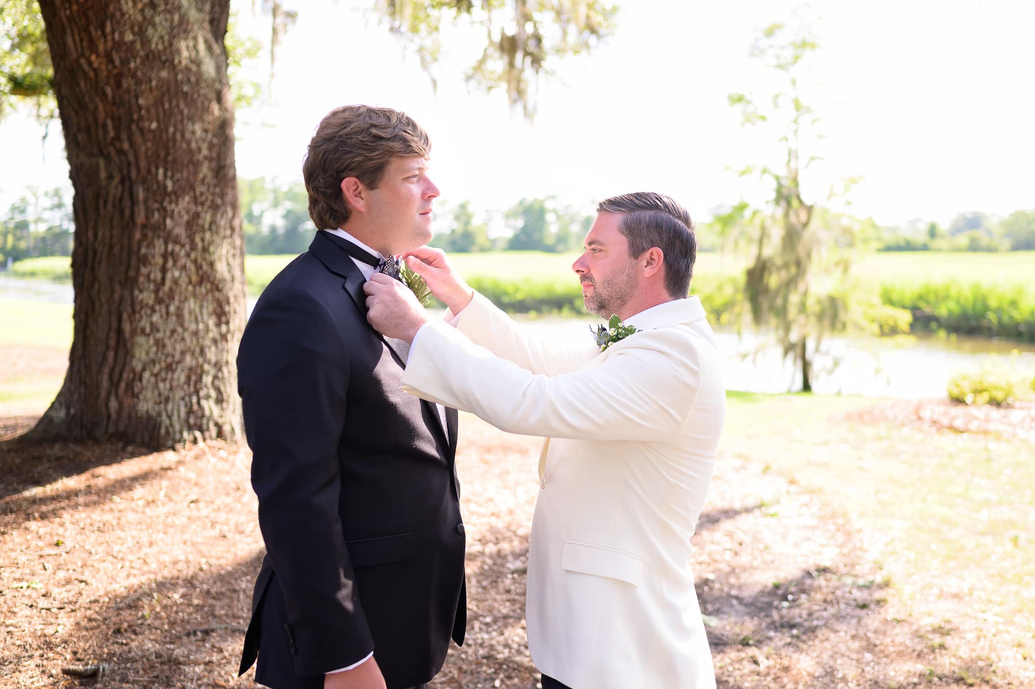 Groom helping best man with his tie - Caledonia Golf & Fish Club