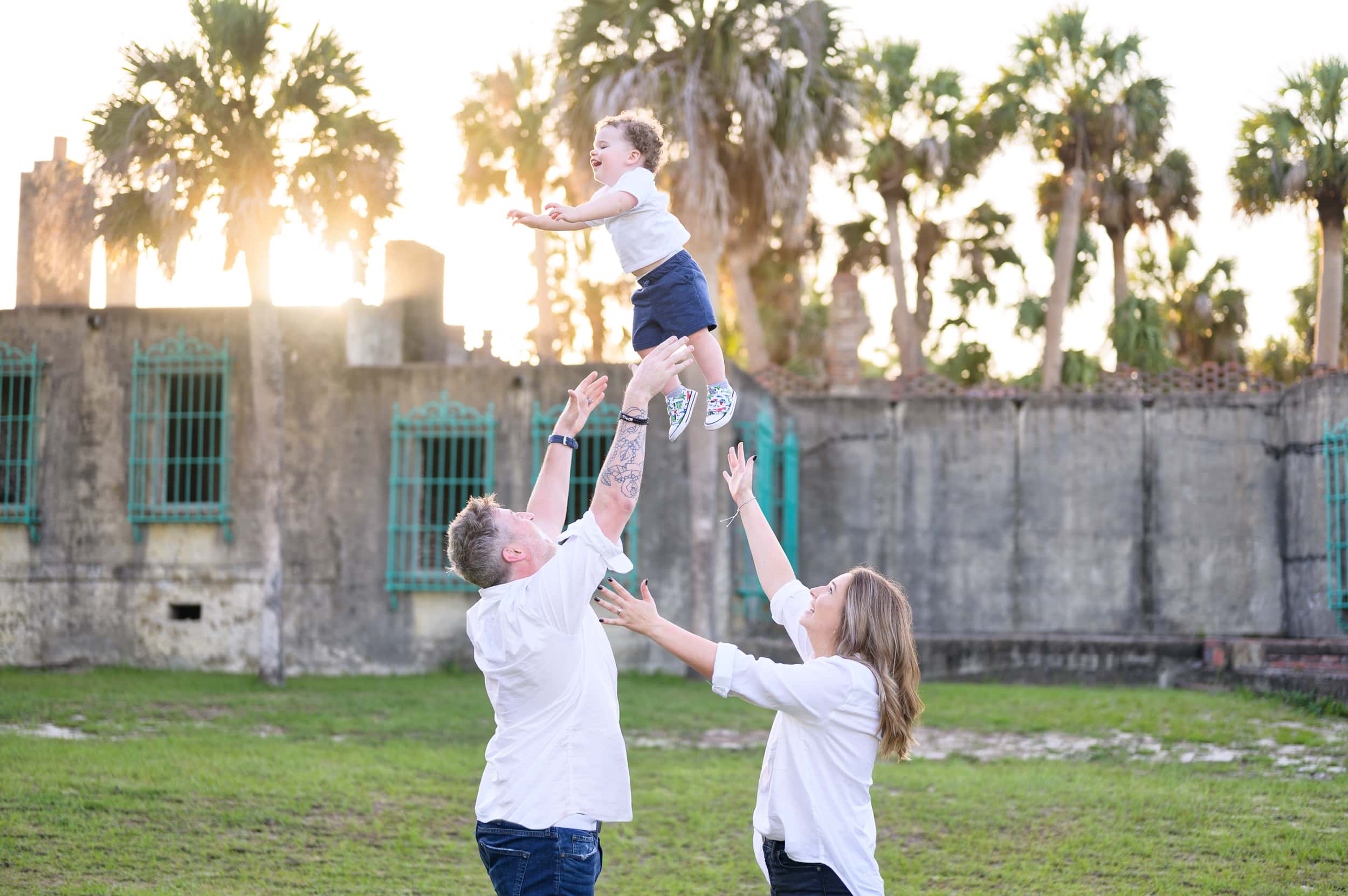 Mom and dad throwing son into the air behind the Atalaya Castle - Huntington Beach State Park