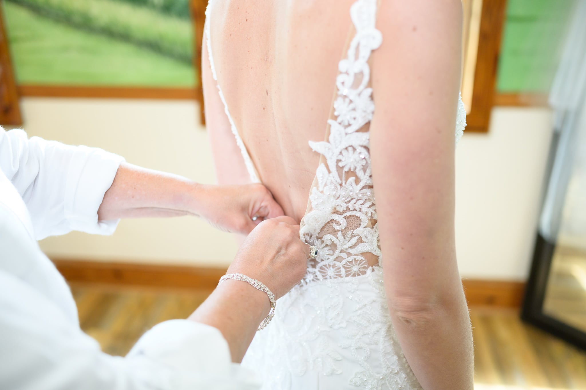 Mom buttoning up bride's dress - Caledonia Golf & Fish Club