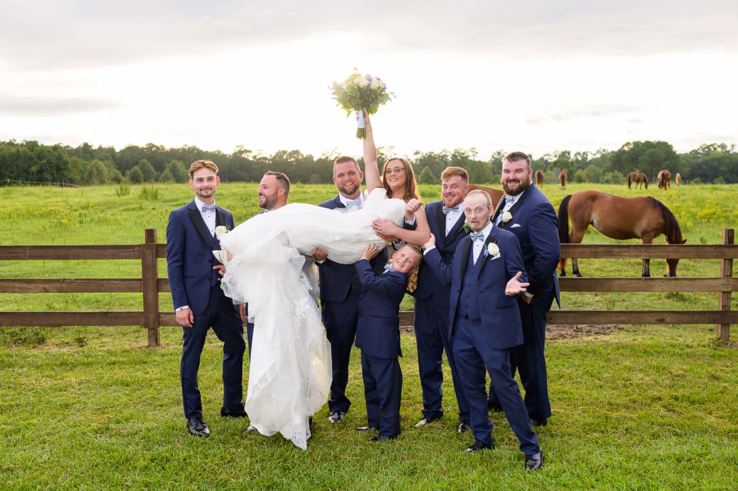 Groomsmen lifting bride into the air - Wildhorse at Parker Farms