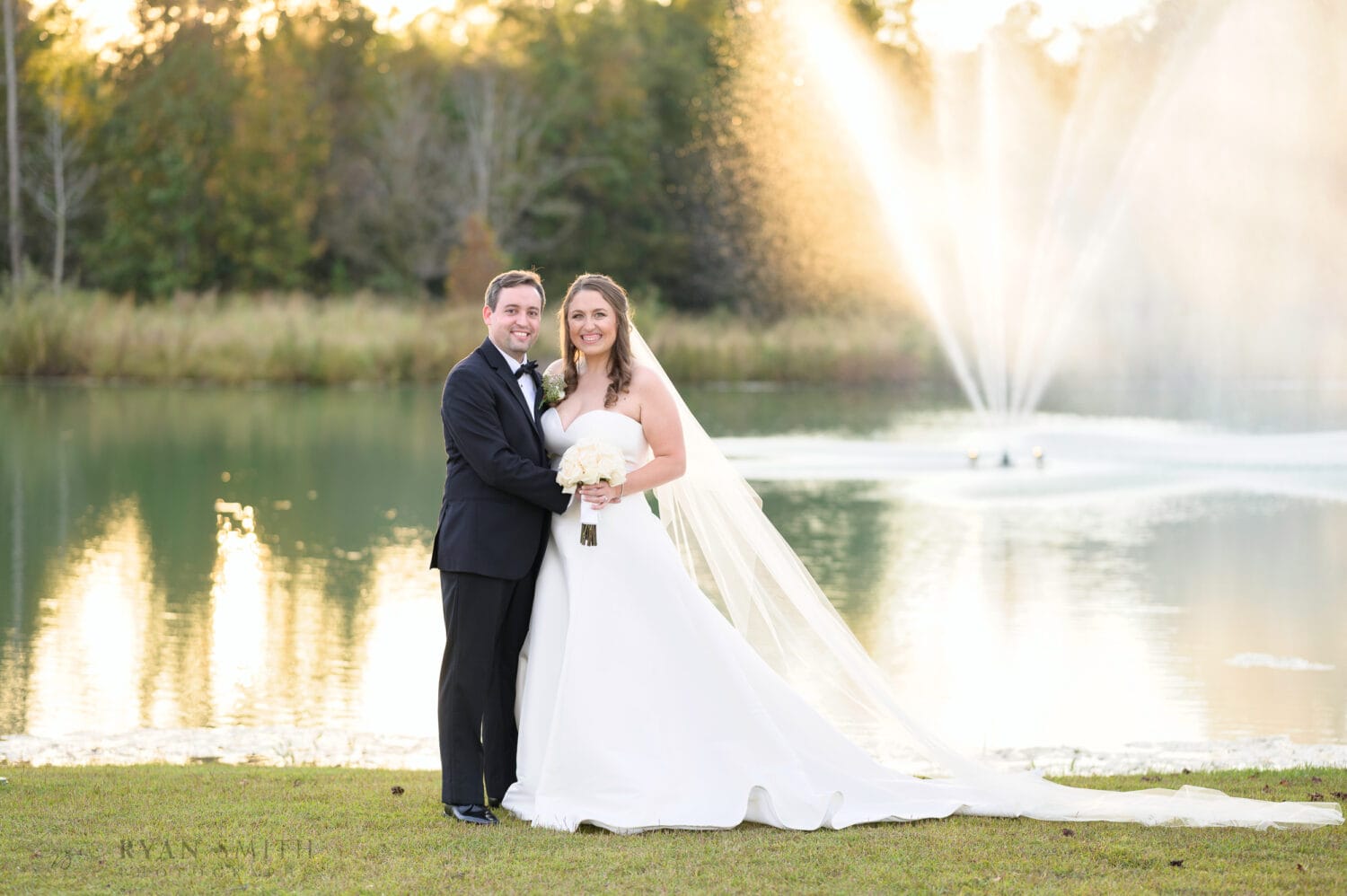 Bride and groom portrait in front of the lake fountain - The Venue at White Oaks Farm