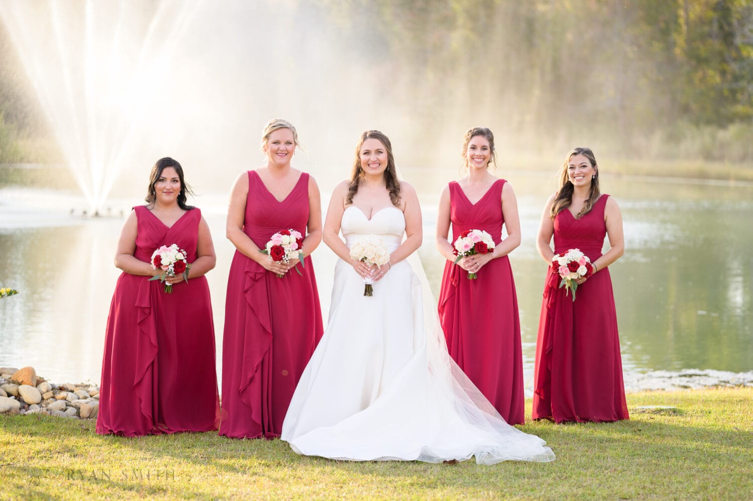 Bride with bridesmaids in front of the fountain - The Venue at White Oaks Farm