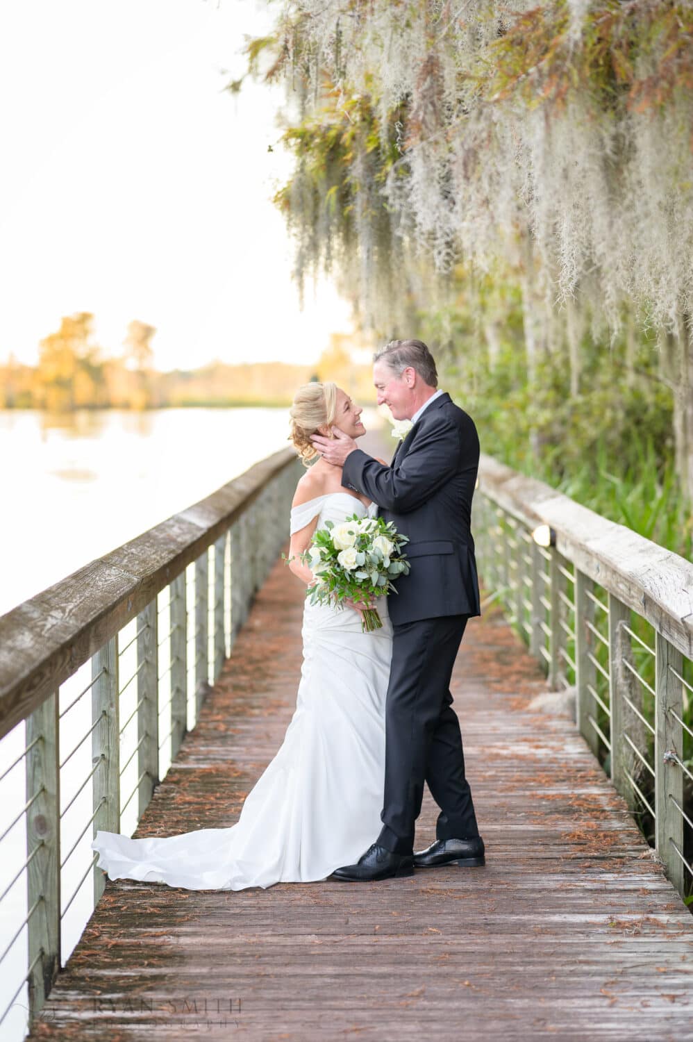 Groom pulling bride in for a kiss on the boardwalk - Safe Harbor Reserve Harbor Yacht Club