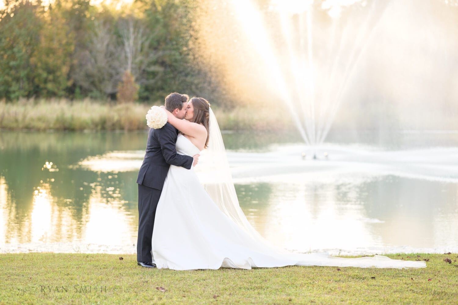 Kiss in front of the fountain - The Venue at White Oaks Farm