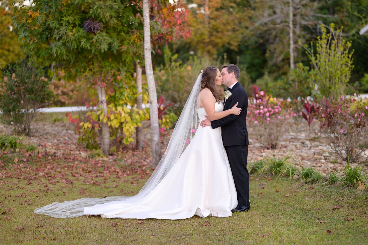 Kiss in front of the garden flowers - The Venue at White Oaks Farm