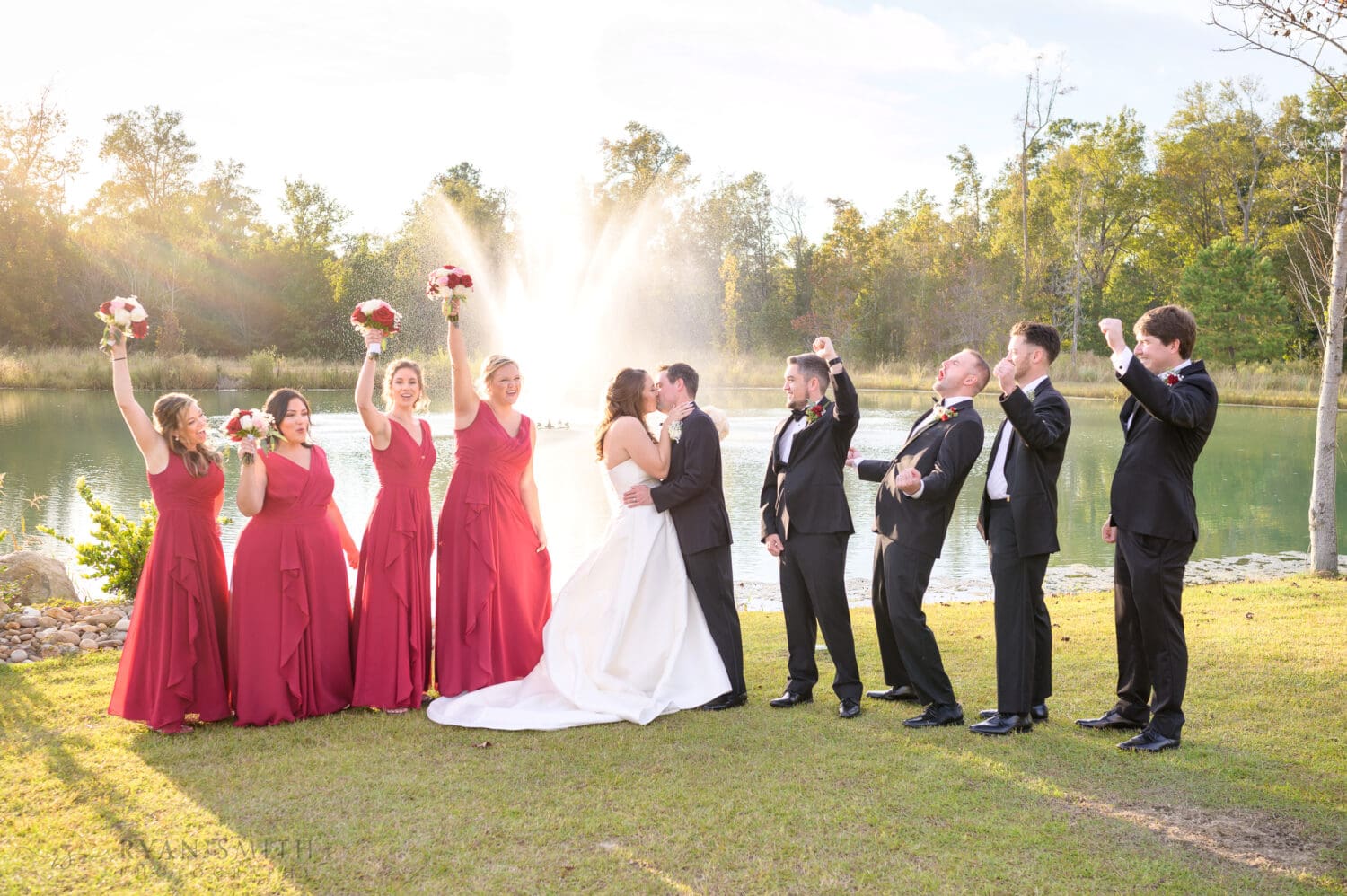 Kiss with the bridal party cheering - The Venue at White Oaks Farm